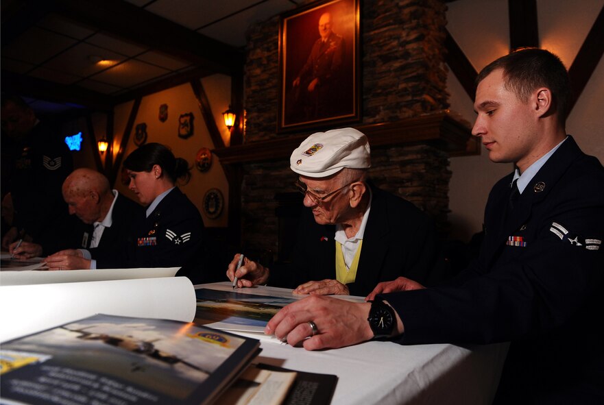 OFFUTT AIR FORCE BASE, Neb. -- Doolittle Raider Thomas Griffin, a navigator on crew 9, signs autographs at the Doolittle Raiders Lounge here April 15, as Airman 1st Class Paul Imm, 55th Operations Support Squadron, assists. The autograph session was part of the raider's 69th annual reunion, which took place this year in Nebraska from April 14-17. (Air Force photo by Josh Plueger)