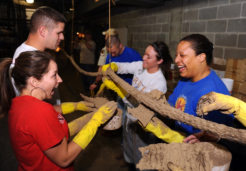 OFFUTT AIR FORCE BASE, Neb. - Offutt volunteers are all smiles as they create a faux vine to be used in one of the gorilla exhibits as part of Offutt's annual spring zoo cleanup, April 16. The zoo cleanup has several unique maintenance requirements such as getting dirty and creating imitation vines from a rope which in turn will save the zoo thousands of dollars. U.S. Air Force Photo by Josh Plueger (released)
