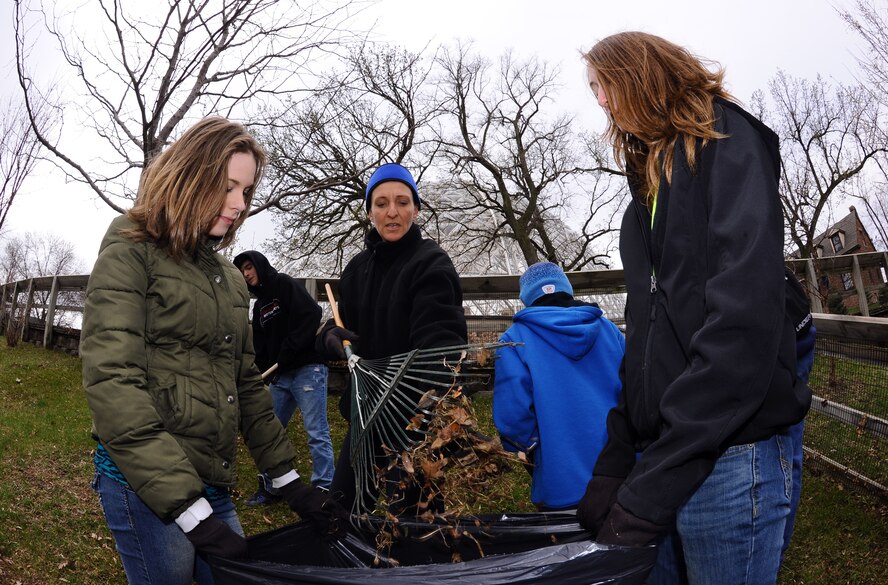 OFFUTT AIR FORCE BASE, Neb. - Master Sgt. Teresa Grant fills a bag with leaves alongside her daughters Tatum (right) and Kaylee (left) as part of Offutt's annual spring zoo cleanup, April 16. The zoo cleanup has several unique maintenance requirements to maintain its operations, however, raking leaves is one of the largest undertakings by Offutt volunteers. U.S. Air Force Photo by Josh Plueger