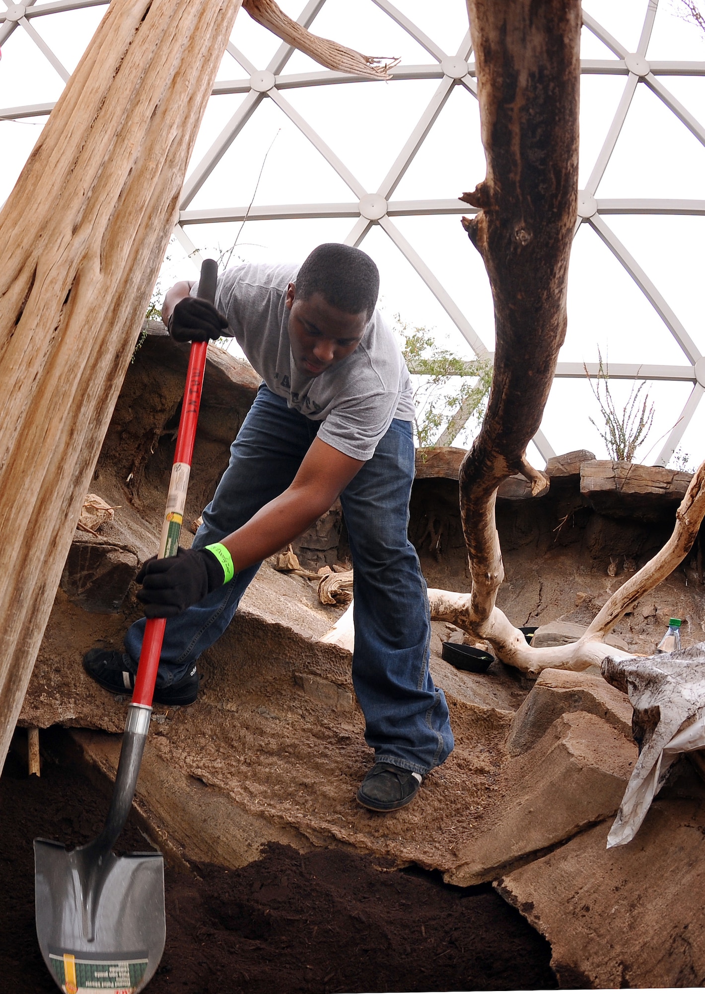 OFFUTT AIR FORCE BASE, Neb.- Airman 1st Class Keitarious Williams, with the 55th Security Forces Squadron, smoothes over fresh fill dirt inside of the Desert Cottontail Rabbit planter as part of Offutt's annual zoo cleanup. U.S. Air Force Photo by  Josh Plueger (released)
