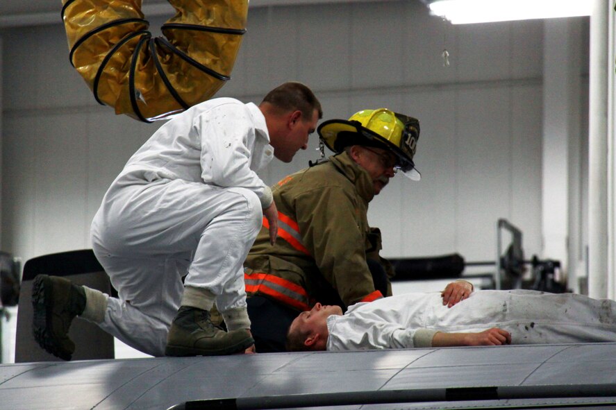 Mr. Chuck Smith, with Allegheny County Airport Authority Fire Rescue, and Staff Sgt Lonnie Coughenour of the 911th Aircraft Maintenance Squadron prepare a stretcher for Senior Airman Larry Wagner during the fuel cell extraction exercise held here April 2.  The exercise was part of the unit compliance inspection held during the April unit training assembly. (U.S. Air Force Photo by SrA Melissa Knox)