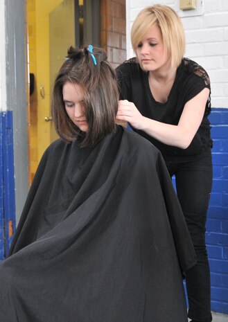 Crystal Hurt, the wife of Senior Airman Tyler Hurt, 437th Operations Support Squadron, receives a free hair cut from Emily Littleton, a stylist who volunteered for a military wives make over April 16, at Armory Park in North Charleston, S.C. The event was hosted by The Look for Success non-profit group and the wives were also treated to a visit from Kim Delaney, a cast member of the television show “Army Wives”. (U.S. Air Force photo /A1C Jared Trimarchi)
