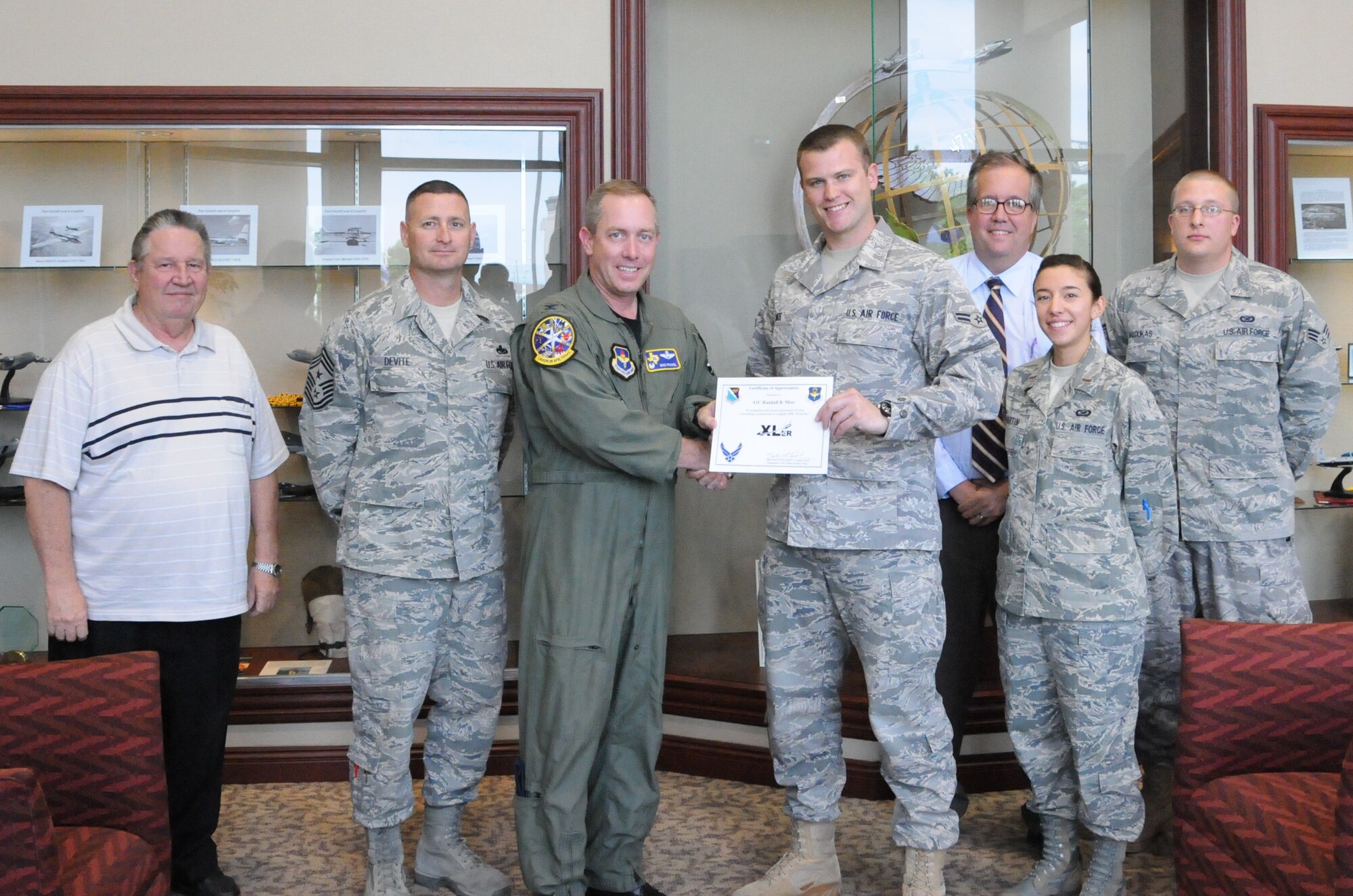 LAUGHLIN AIR FORCE BASE, Texas – Airman 1st Class Blake Mize, 47th Flying Training Wing public affairs, poses with Col. Michael Frankel, 47th FTW commander, Chief Master Sgt. Ray DeVite, 47th FTW command chief, and fellow members of the public affairs team after being presented the XLer of the Week award here April 13. The XLer is a weekly award chosen by wing leadership and presented to those who consistently make outstanding contributions to Laughlin and their unit. (U.S Air Force photo by 2nd Lt. Gabriel Denny) 