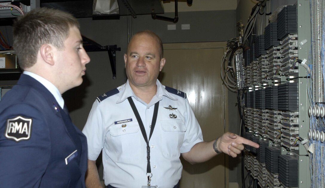 Col. Scott Normandeau, Air Forces Northern communications director, shows Cadet Tyler Atkinson one of the communications systems that helps keep AFNORTH running smoothly. Cadet Atkinson, who will be attending a military college in the fall, spent a day at Tyndall Air Force Base, Fla., shadowing two Air Force communications officers. (U.S. Air Force photo by Angela Pope) 