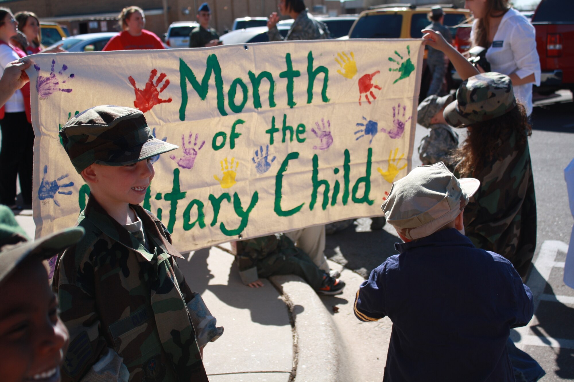 Children at the Cannon Air Force Base, N.M., Child Development Center observed the Month of the Military child April 8, 2011 with a parade around the building while dressed in their parents' uniforms.  CDC employees carried a banner in the parade made with the kids' hand prints. (photo by Alma Castaneda)(RELEASED)
