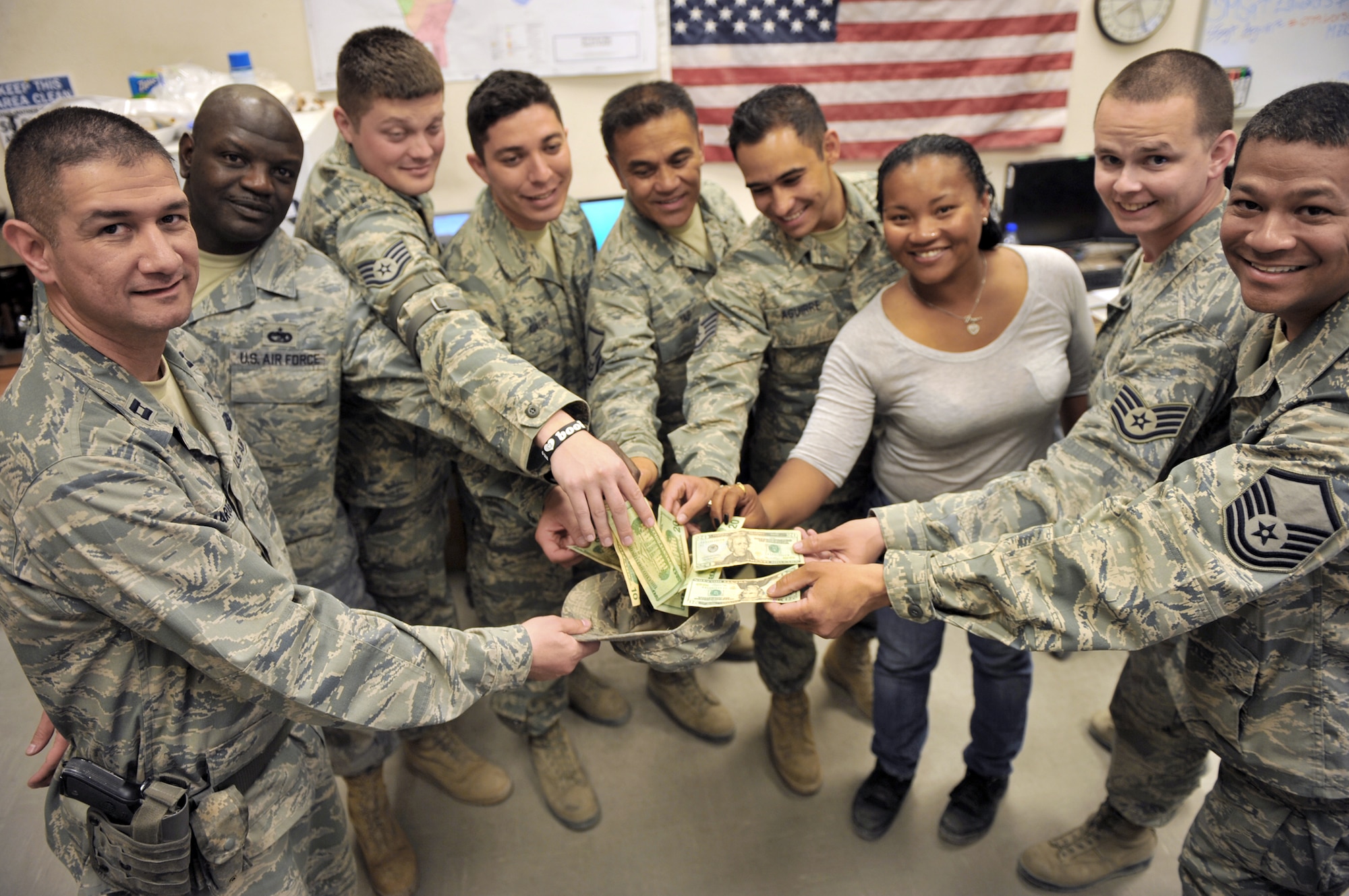 Members from the 455th Expeditionary Aerial Port Squadron and 455th Expeditionary Logistics Readiness Squadron collected monetary donations to replace money stolen from three girls in Georgia. (U.S. Air Force photo/Senior Airman Sheila deVera)