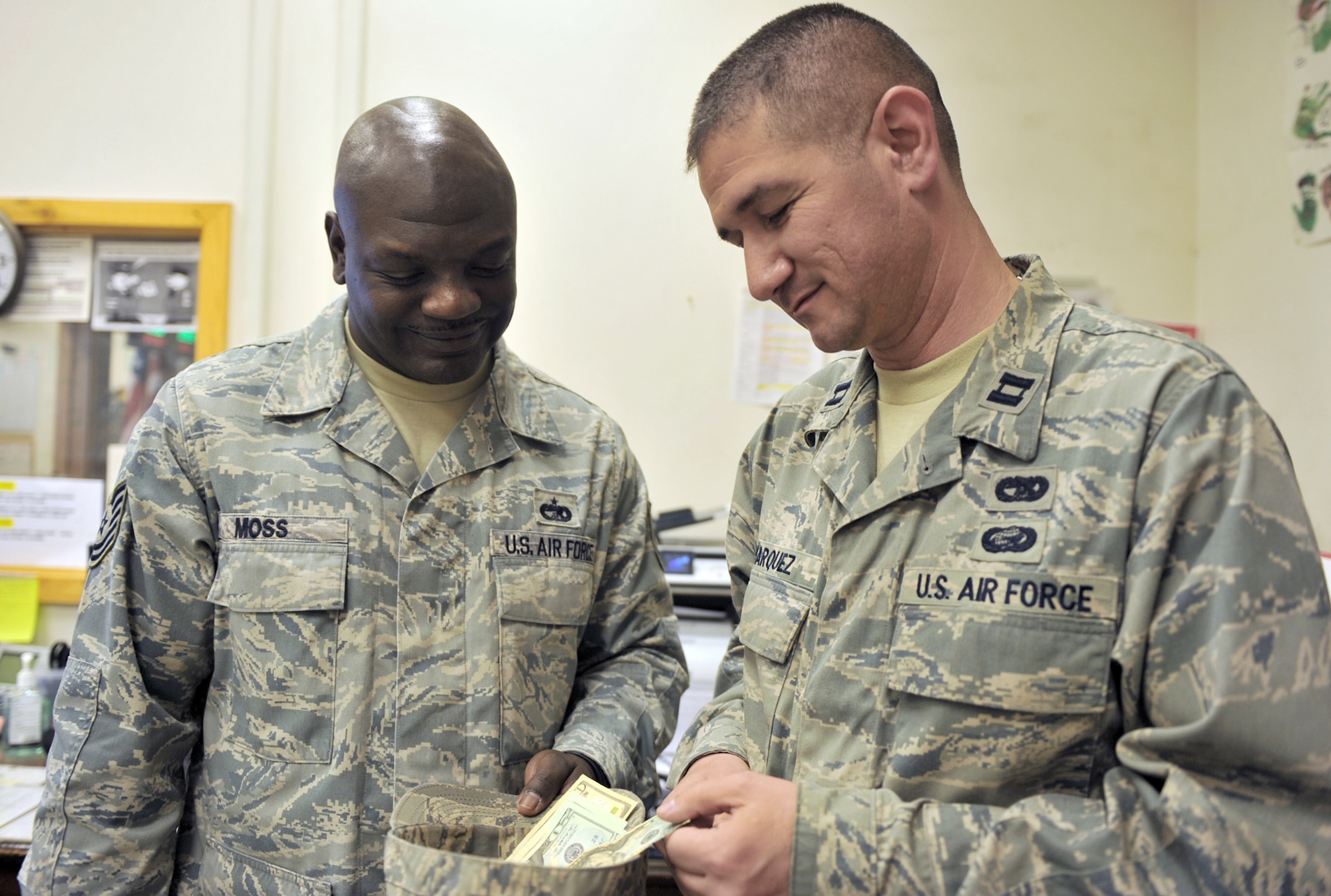 Tech. Sgt. Ladell Moss collects money from Capt. Charles Marquez April 14, 2011, at Bagram Airfield, Afghanistan. Both Airmen are assigned to the 455th Expeditionary Aerial Port Squadron. (U.S. Air Force photo/Senior Airman Sheila deVera)