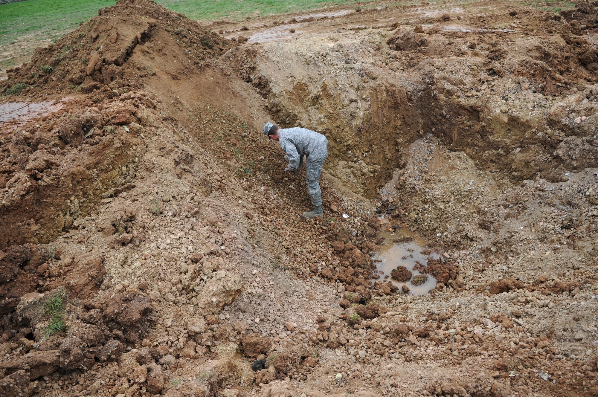 SPANGDAHLEM AIR BASE, Germany – Staff Sgt. Adam Combs, 52nd Equipment Maintenance Squadron tactical aircraft maintenance craftsman, clears debris from the crash site of an Air Force A-10 Thunderbolt II near Laufeld, Germany, April 14.  The aircraft crashed April 1 in a field outside Laufeld, a town north of the city of Wittlich. The pilot, Lt. Col. Scott Hurrelbrink, 81st Fighter Squadron, here was treated for injuries at the Krankenhaus der Barmherzigen Bruder, and no one else was injured due to the mishap. (U.S. Air Force photo/Airman 1st Class Matthew B. Fredericks)
