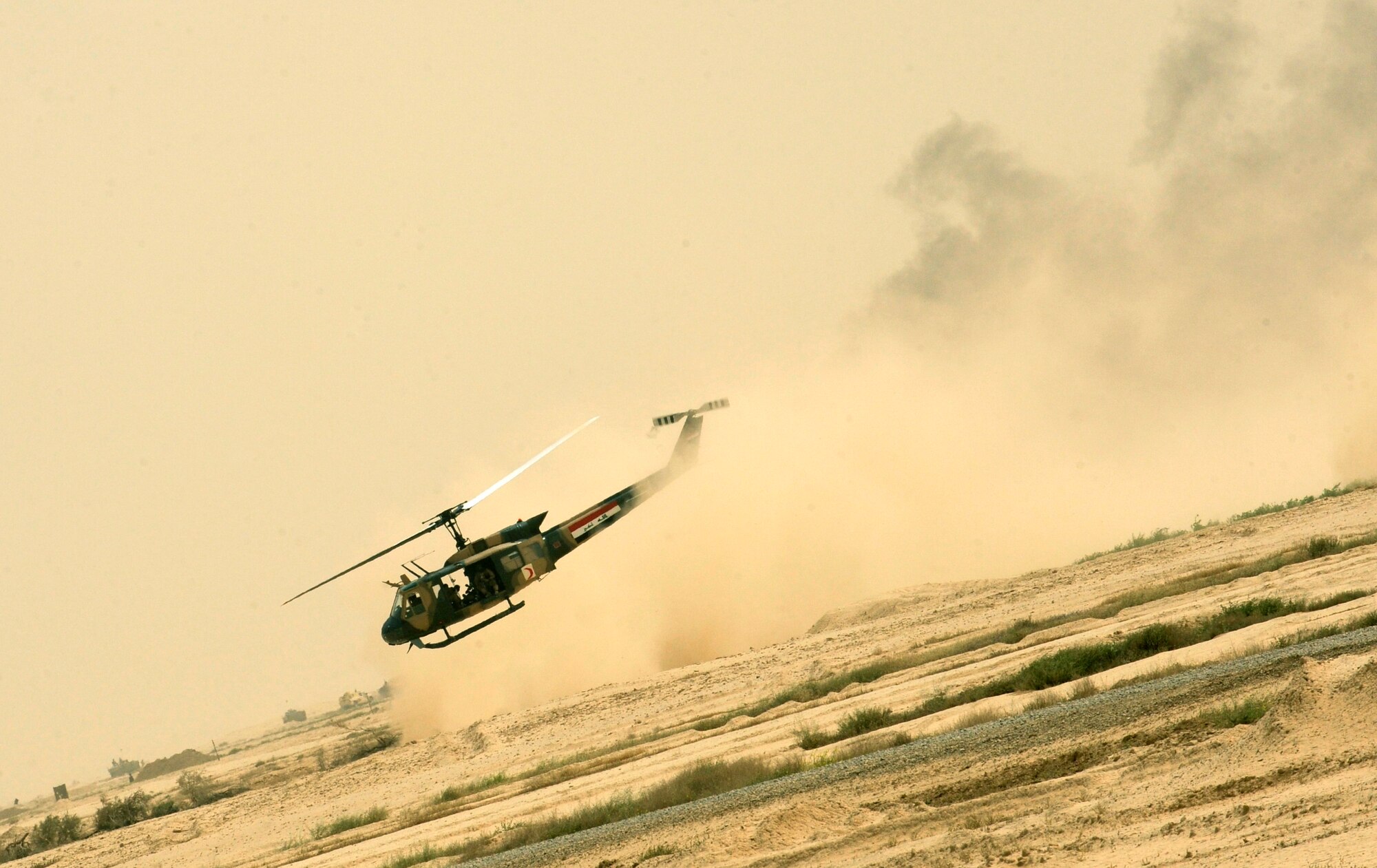 BESMAYA RANGE COMPLEX, Iraq –An Iraqi UH-1 Huey lifts off from the battle scene carrying simulated casualties during a joint demonstration near Baghdad April 18. The exhibition was just one of several ongoing, multi-phase exercises designed to further integrate the Iraqi air force, Iraqi Army Aviation Command and Iraqi army. (U.S. Air Force photo by Tech. Sgt. Randy Redman)