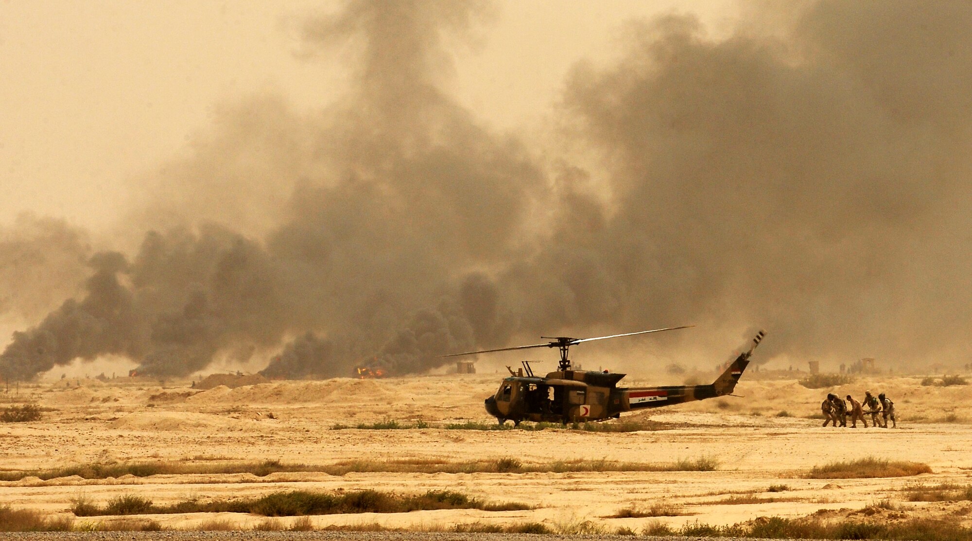 BESMAYA RANGE COMPLEX, Iraq – The aircrew from an Iraqi UH-1 Huey carry simulated casualties away from the battle scene during a joint demonstration near Baghdad April 18. The exhibition was just one of several ongoing, multi-phase exercises designed to further integrate the Iraqi air force, Iraqi Army Aviation Command and Iraqi army. (U.S. Air Force photo by Tech. Sgt. Randy Redman)