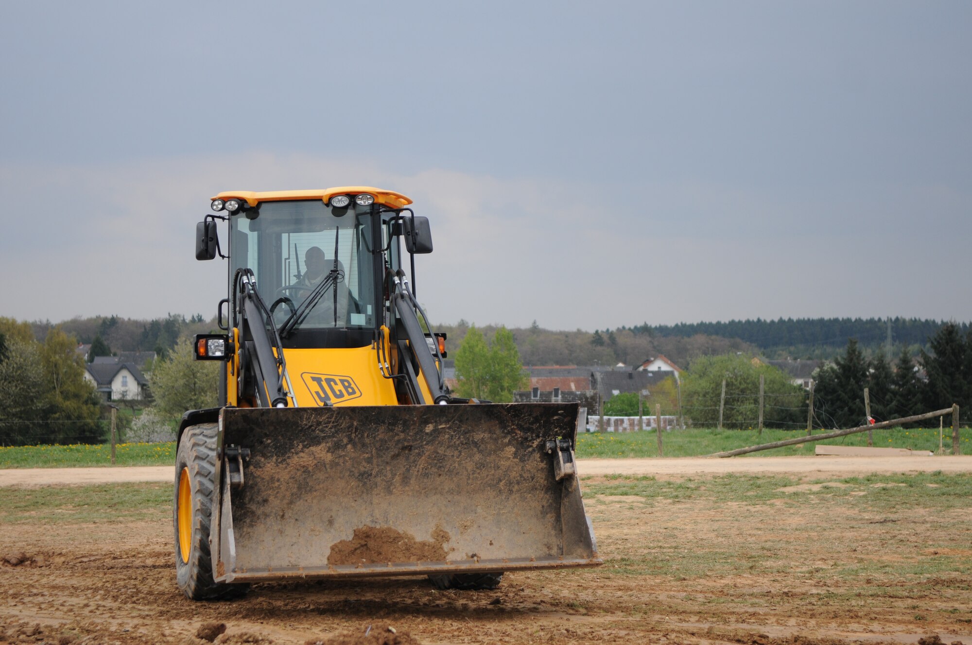 SPANGDAHLEM AIR BASE, Germany – Airman 1st Class Craig Joseph, 52nd Civil Engineer Squadron pavement and equipment operations apprentice, operates a front-loader to clear debris from the crash site of an Air Force A-10 Thunderbolt II near Laufeld, Germany, April 14. The aircraft crashed April 1 in a field outside Laufeld, a town north of the city of Wittlich. The pilot, Lt. Col. Scott Hurrelbrink, 81st Fighter Squadron, here was treated for injuries at the Krankenhaus der Barmherzigen Bruder, and no one else was injured in the mishap. The Safety Investigation Board is continuing its investigation into the cause of the crash.  (U.S. Air Force photo/Airman 1st Class Matthew B. Fredericks)