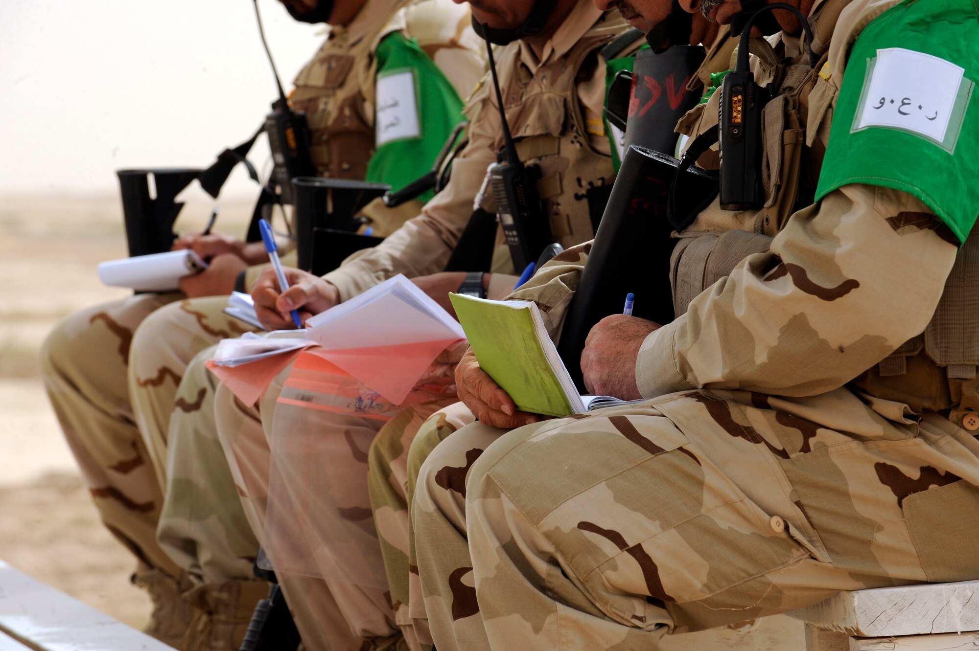 BESMAYA RANGE COMPLEX, Iraq -- Soldiers from the Iraqi Ground Forces Command, Ninth Mechanized Infantry Division, take notes during a briefing prior to a joint military demonstration near Baghdad April 18. The exhibition was just one of several ongoing, multi-phase exercises designed to further integrate the Iraqi air force, Iraqi Army Aviation Command and Iraqi army. (U.S. Air Force photo by Tech. Sgt. Randy Redman)