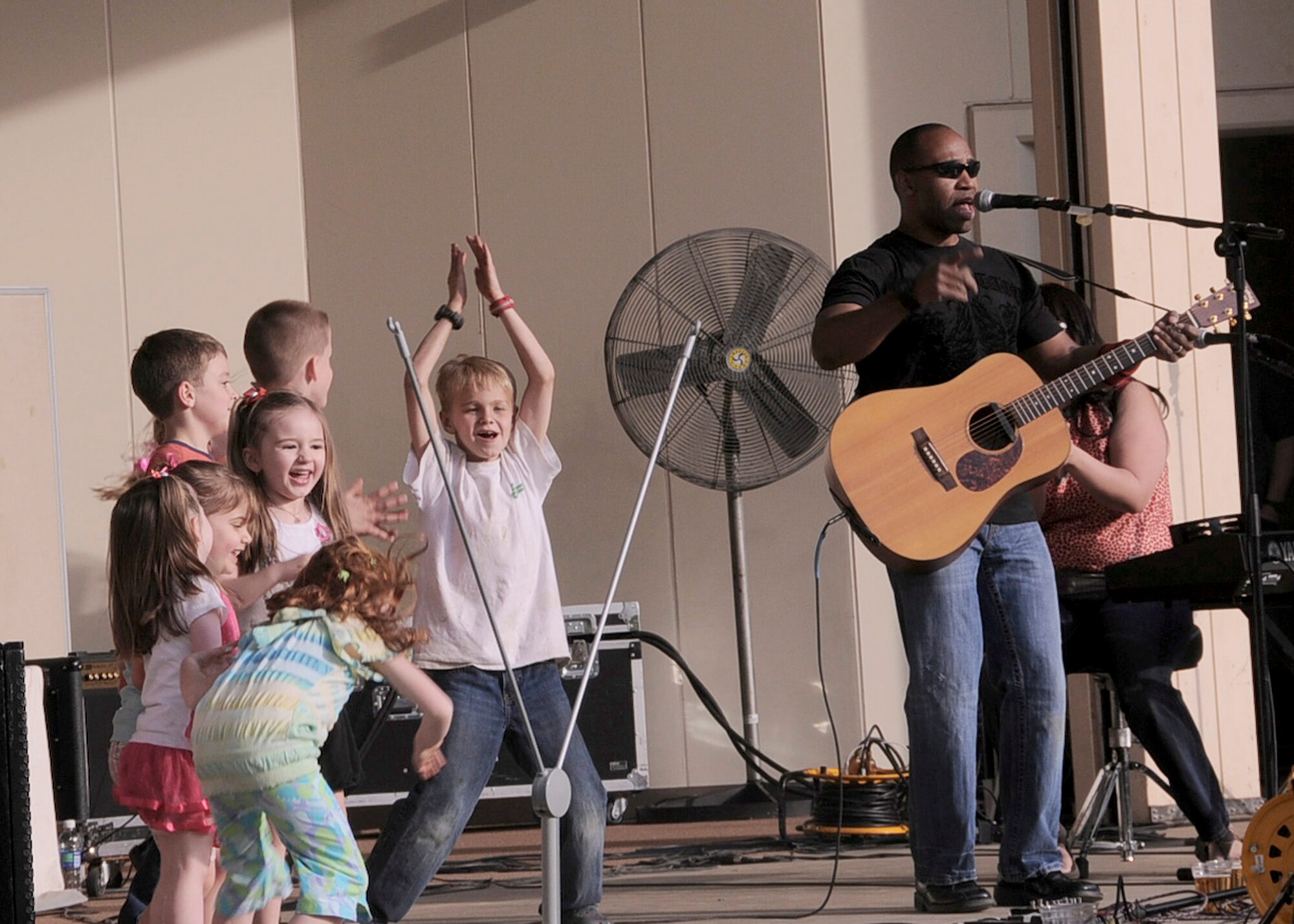 YOKOTA AIR BASE, Japan -- Children dance on stage April 16, 2011, at Yokota Air Base, Japan, as the band Days Gone By performs during Tomodachistock 2011. More than 700 people gathered at the free event to enjoy music and food while helping the American Red Cross raise money to support the earthquake and tsunami relief efforts. (U.S. Air Force photo/Senior Airman Andrea Salazar)