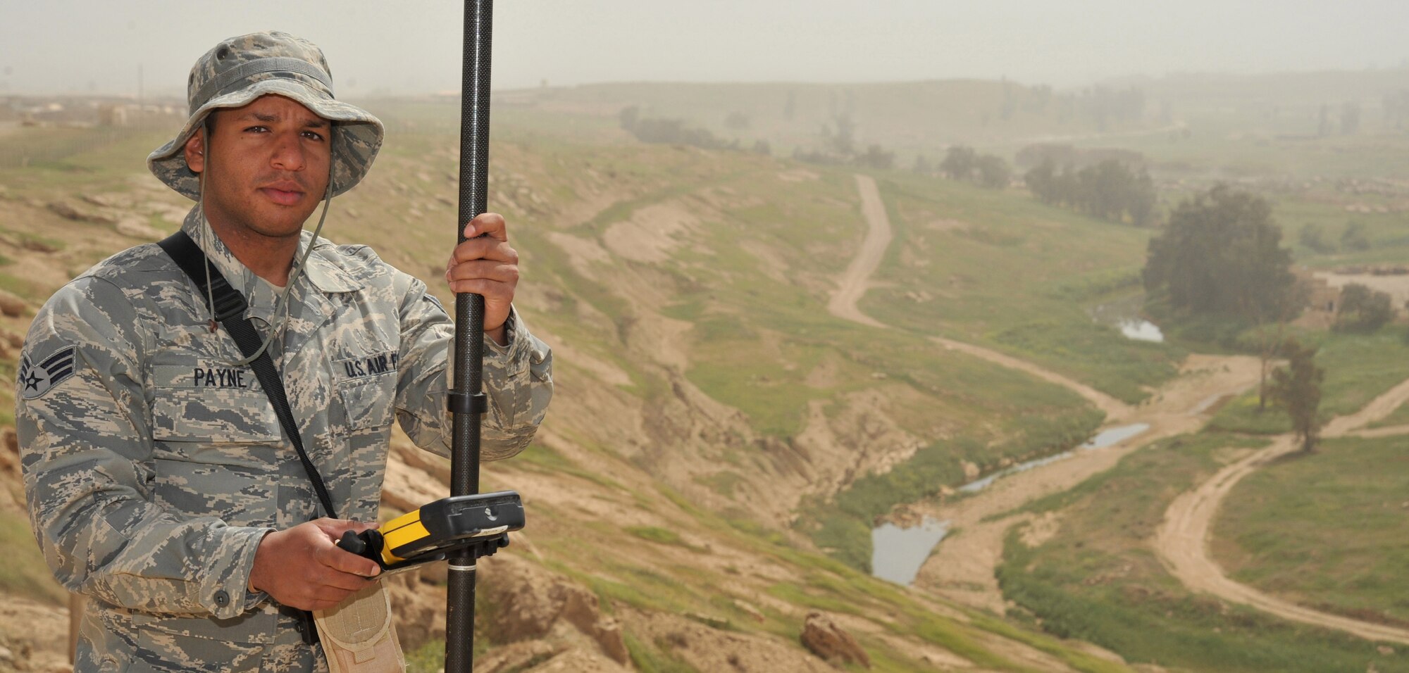 Senior Airman Michael Payne, a 467th Expedition Prime Beef Squadron engineering assistant, poses for a photo with his site surveying equipment, April 13, 2011, at Contingency Operating Site Marez. (U.S. Air Force photo by Senior Airman Andrew Lee/Released) 