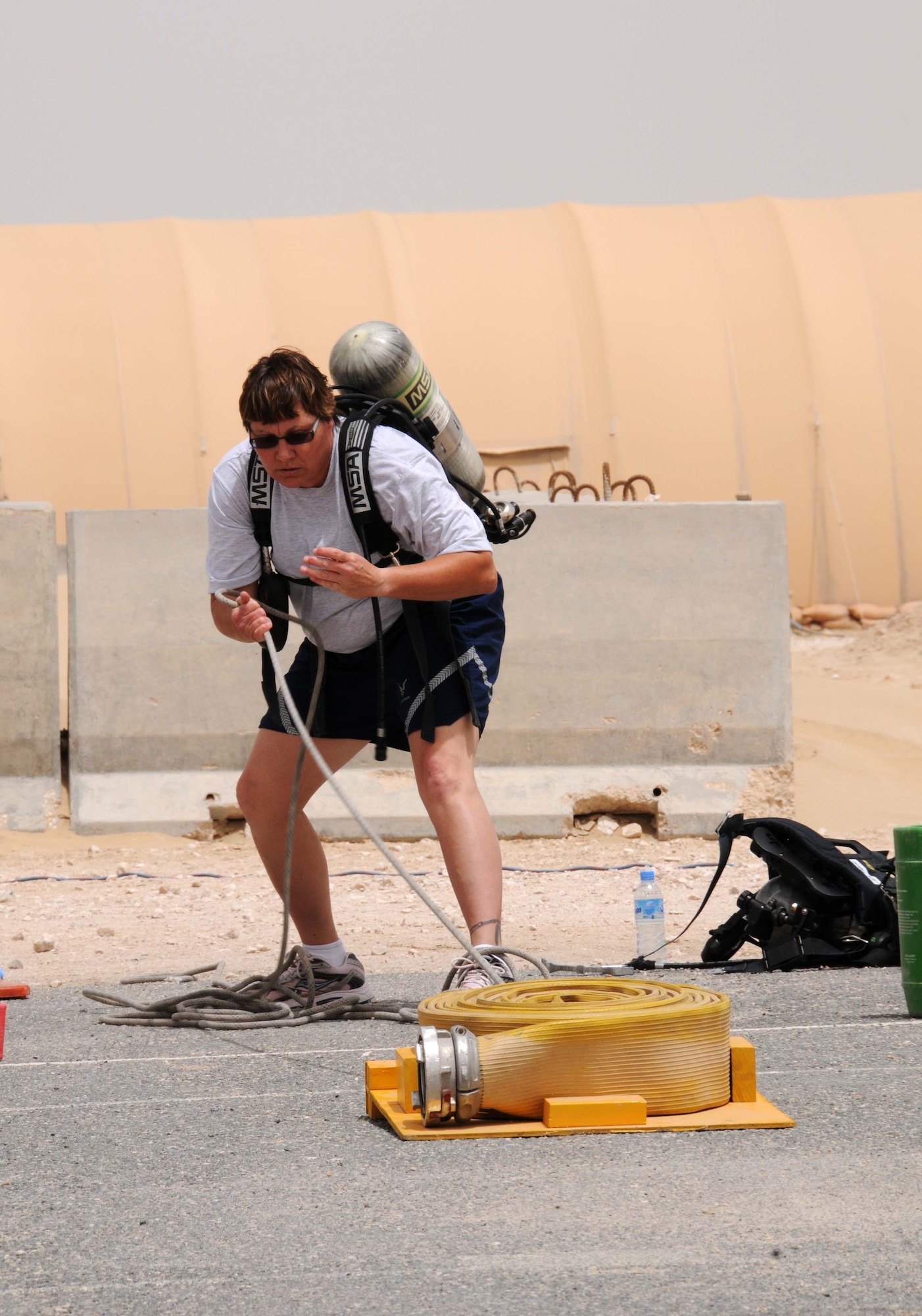 Master Sgt. Valerie Uken from the 379th Air Expeditionary Wing Ground Safety Office drags a rope during the Fire Muster April 16 in Southwest Asia. MSgt Uken competed in the individual competition and took 2nd place. (U.S. Air Force photo/Staff Sgt Anthony Graham)