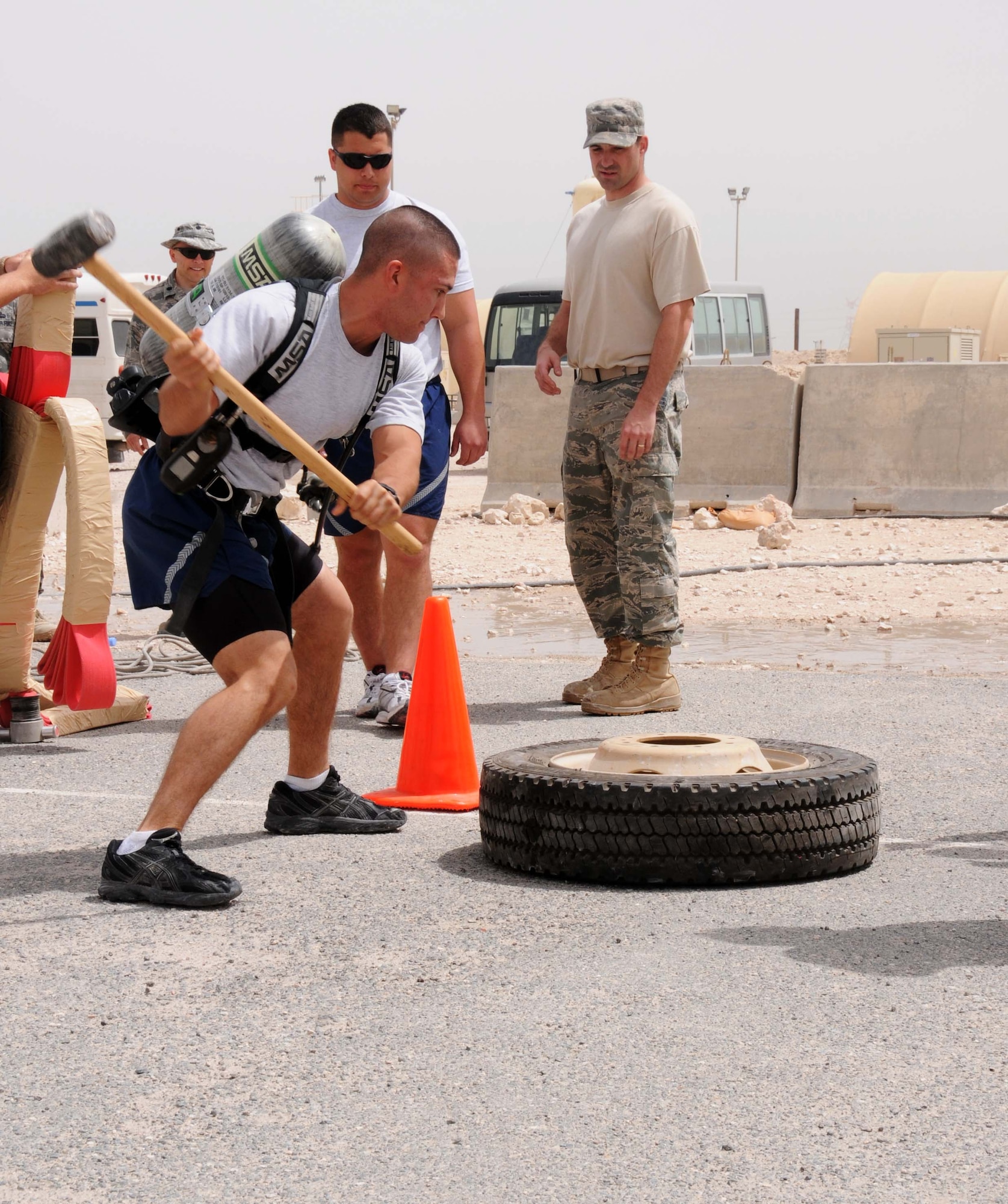 Airman 1st Class Tyler Crawford, 379th Expeditionary Communications Squadron, swings a sledge hammer as he tries to move the tire past the white line April 16 in Southwest Asia. Airman Crawford and many other Airmen competed in the Fire Muster put on by the 379th Expeditionary Civil Engineer Squadron. (U.S. Air Force photo/Staff Sgt Anthony Graham)