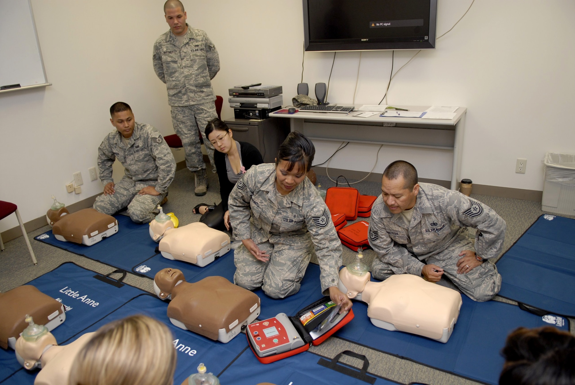Tech. Sgt. Jeanette Espiritu, a basic life support administrator, demonstrates how to apply automated external defibrillator, or AED, pads during a Heartsaver class on Kadena Air Base, April 15. Sergeant Espiritu taught the use of AEDs during a class which taught students the new American Heart Association CPR method of administering immediate chest compressions. (U.S. Air Force photo/Airman 1st Class Tara A. Williamson)
