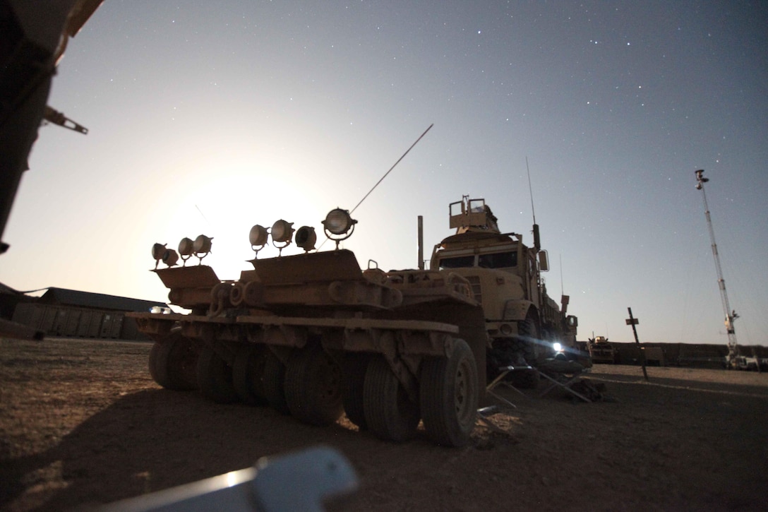 A Marine plays a game on his portable media player as the moon rises over the horizon behind the Mine Resistant Ambush Protected vehicle. The Marines and sailors say it’s a treat to sleep outside because they get to see a sky that’s untainted by artificial light. They stay pretty busy during the day, so at night, when all becomes calm, the Marines try to unwind by playing video games or cards and sleeping after a hard day’s work. ::r::::n::::r::::n::::r::::n::