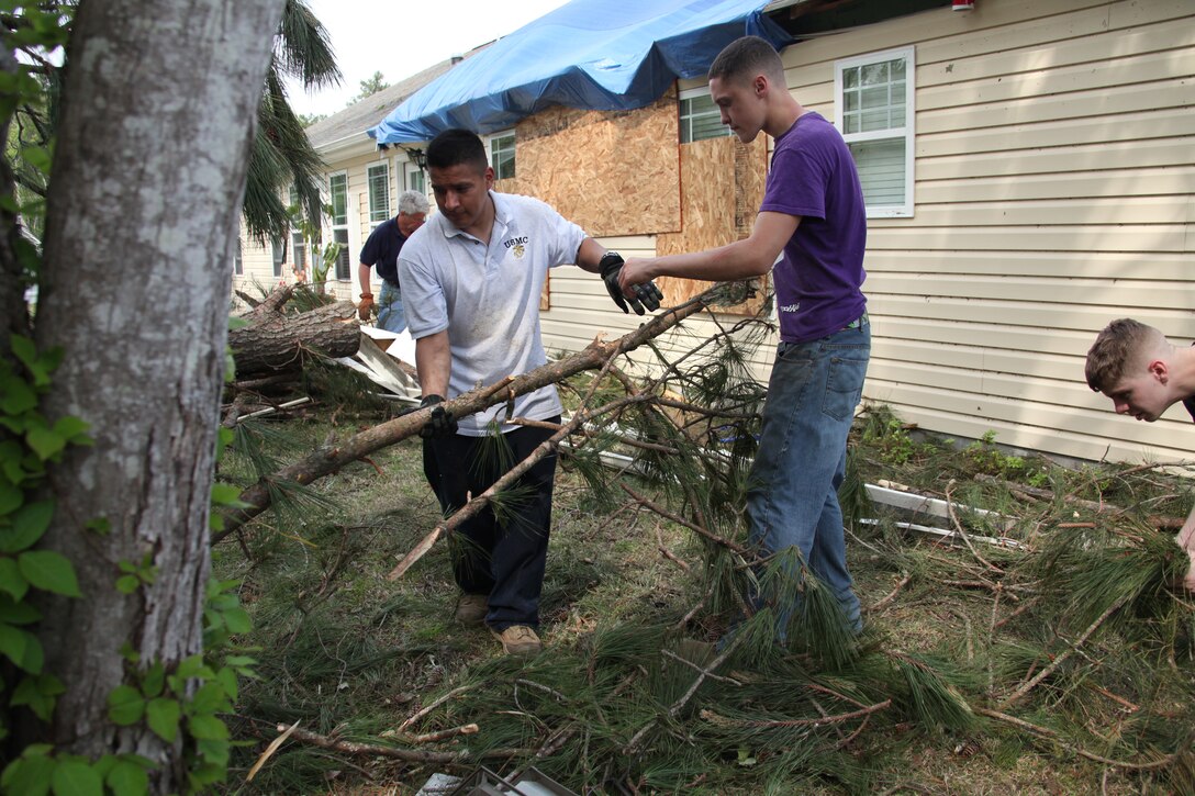 Cpl. Daniel M. Nunez-Galvan, left, and Lance Cpl. Robert W. Neerbasch help clear debris April 17 after an F-3 tornado hit the Village of Falcon Bridge near New Bern, N.C., the previous night. Nunez-Galvan and Neerbasch, as well as many of the Marines and Sailors from Cherry Point-based units, volunteered to help their local community in its time of need. Both are supply clerks with 2nd Low Altitude Air Defense Battalion.