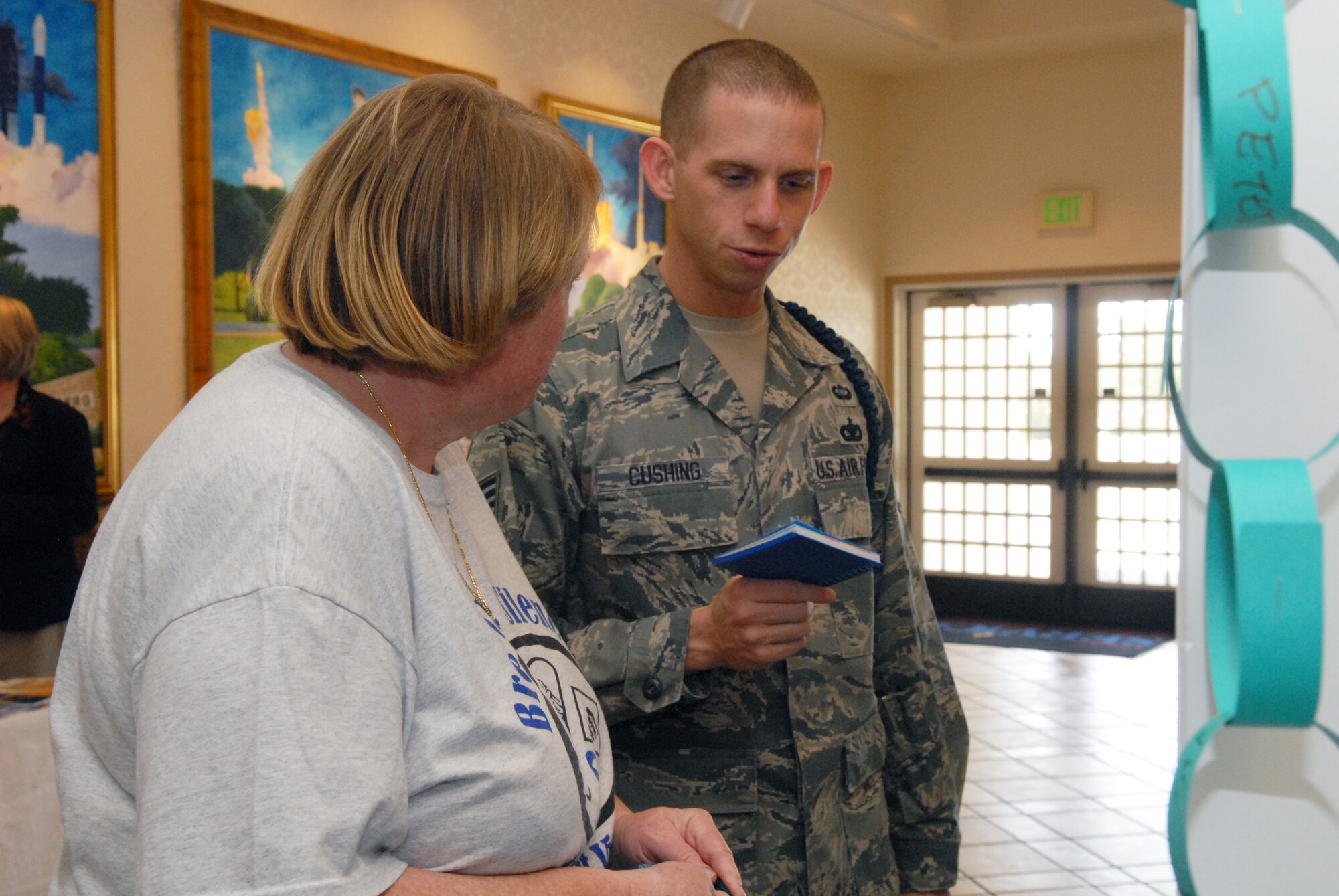 VANDENBERG AIR FORCE BASE, Calif. – Donna Rathbun, Sexual Assault Prevention and Response Coordinator, gives Staff Sgt. Ryan Cushing, 381st Training Support Squadron, a SARC promotional notepad and pen Wednesday, April 20, 2011, in the Pacific Coast Club here. April is designated as April Awareness month, a campaign on National Sexual Assault Awareness, Child Abuse Awareness and Prevention, Alcohol Awareness and Month of the Military Child. (U.S. Air Force photo/Jerry E. Clemens, Jr.)