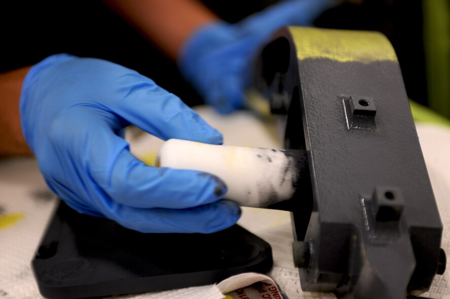 An Airman from the 23rd Equipment Maintenance Squadron finishes painting the hoist support brackets off an HH-60G Pave Hawk at Moody Air Force Base, Ga., April 20. The 23rd EMS is responsible for corrosion control on the A-10C Thunderbolt II, the Pave Hawk, and smaller components of the HC-130P Combat King. (U.S. Air Force photo/Airman 1st Class Benjamin Wiseman)(RELEASED)