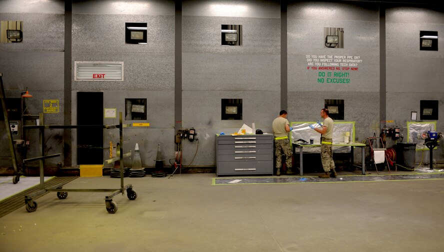 Staff Sgt. Jordan Keller and Airman 1st Class Taylor Jacobs, 23rd Equipment Maintenance Squadron aircraft structural maintenance, prepare to paint hoist support brackets off an HH-60G Pave Hawk at Moody Air Force Base, Ga., April 20. The 23rd EMS paints the metal components to prevent the corrosion and to beautify the aircraft stationed at Moody. (U.S. Air Force photo/Airman 1st Class Benjamin Wiseman)(RELEASED)
