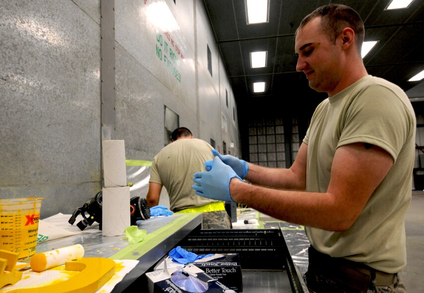 Staff Sgt. Jordan Keller, 23rd Equipment Maintenance Squadron aircraft structural maintenance craftsman, dons gloves while preparing to paint metal components from an HH-60G Pave Hawk at Moody Air Force Base, Ga., April 20. Due to Georgia’s various weather conditions and Moody’s high tempo for training and deployments, the 23rd EMS works daily operations to keep the base’s assets corrosion-free. (U.S. Air Force photo/Airman 1st Class Benjamin Wiseman)(RELEASED)