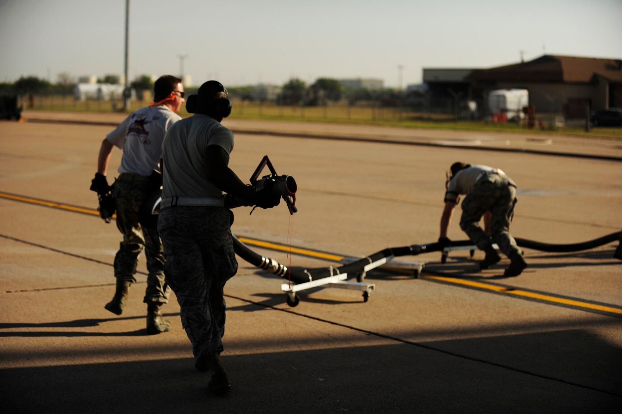 Airmen from California Air National Guard's 146th Airlift Wing, North Carolina Air National Guard's 145th Airlift Wing and Wyoming Air National Guard's 153rd Airlift Wing remove a fire retardant hose from a C-130H Hercules equipped with the Modular Airborne Firefighting System at Dyess Air Force Base, Texas, April 19, 2011.  MAFFS is capable of dispensing 3,000 gallons of water or fire retardant in under 5 seconds.  Wildfires have spread across various parts of Texas and have burned more than 1,000 square miles of land.  (U.S. Air Force Photo/Staff Sgt. Eric Harris)
