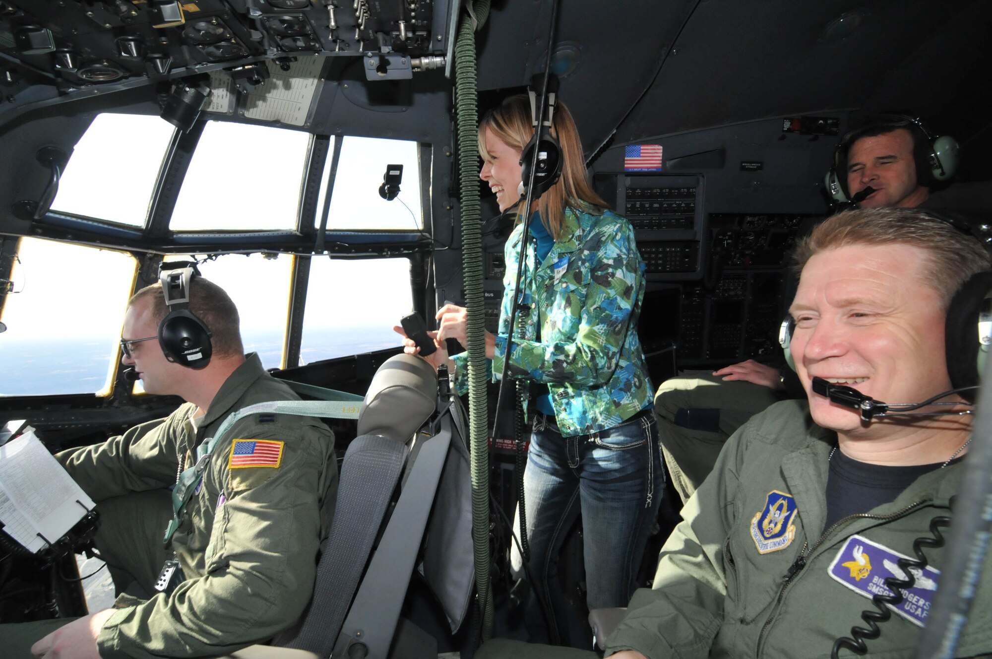 Kim Milne (center) Lakeville South School District, gets a view from the cockpit with c Capt. Brandon Schrader, co-pilot, and Flight Engineer Senior Master Sgt. Bill Rogers during the Educators Flight April 13. (Air Force Photo/Paul Zadach)