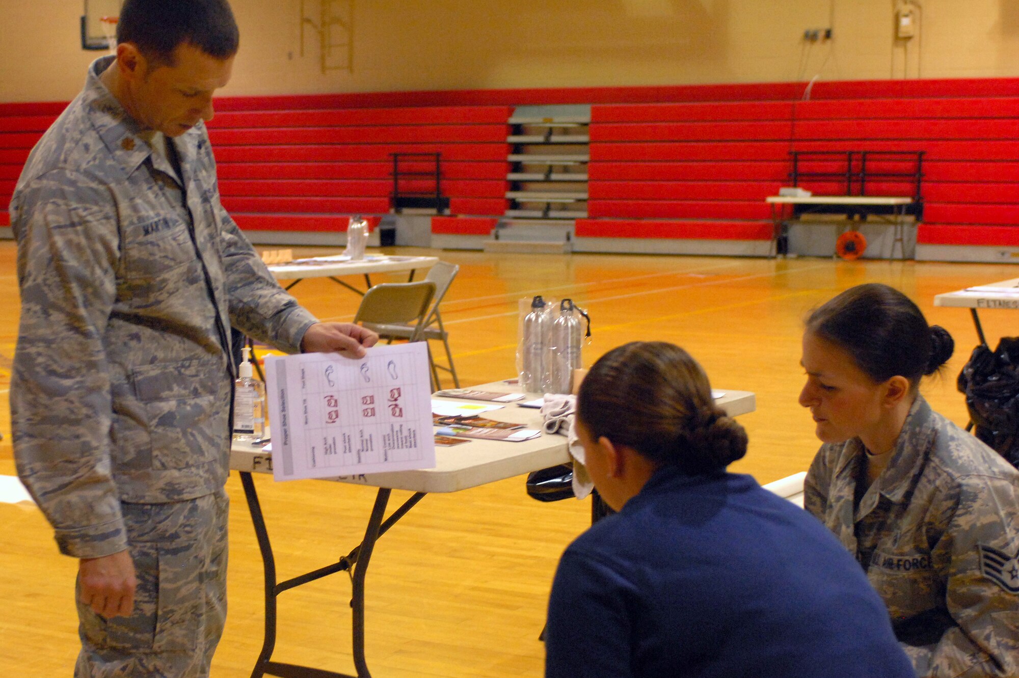Maj. Justin Martin, 20th Medical Group physical therapy flight commander, shows Airman 1st Class Lauren Dezort, 20th Force Support Squadron fitness apprentice, her foot type as Staff Sgt. Sharon Munster, 20th MDG physical therapy flight non-commissioned officer in charge, looks on at the Shaw fitness center April 13, 2011. The Health and Wellness Center sponsored the running shoe clinic to provide advice and assistance on Team Shaw members’ selection of shoes.  (U.S. Air Force photo by Senior Airman Alexandria Mosness)