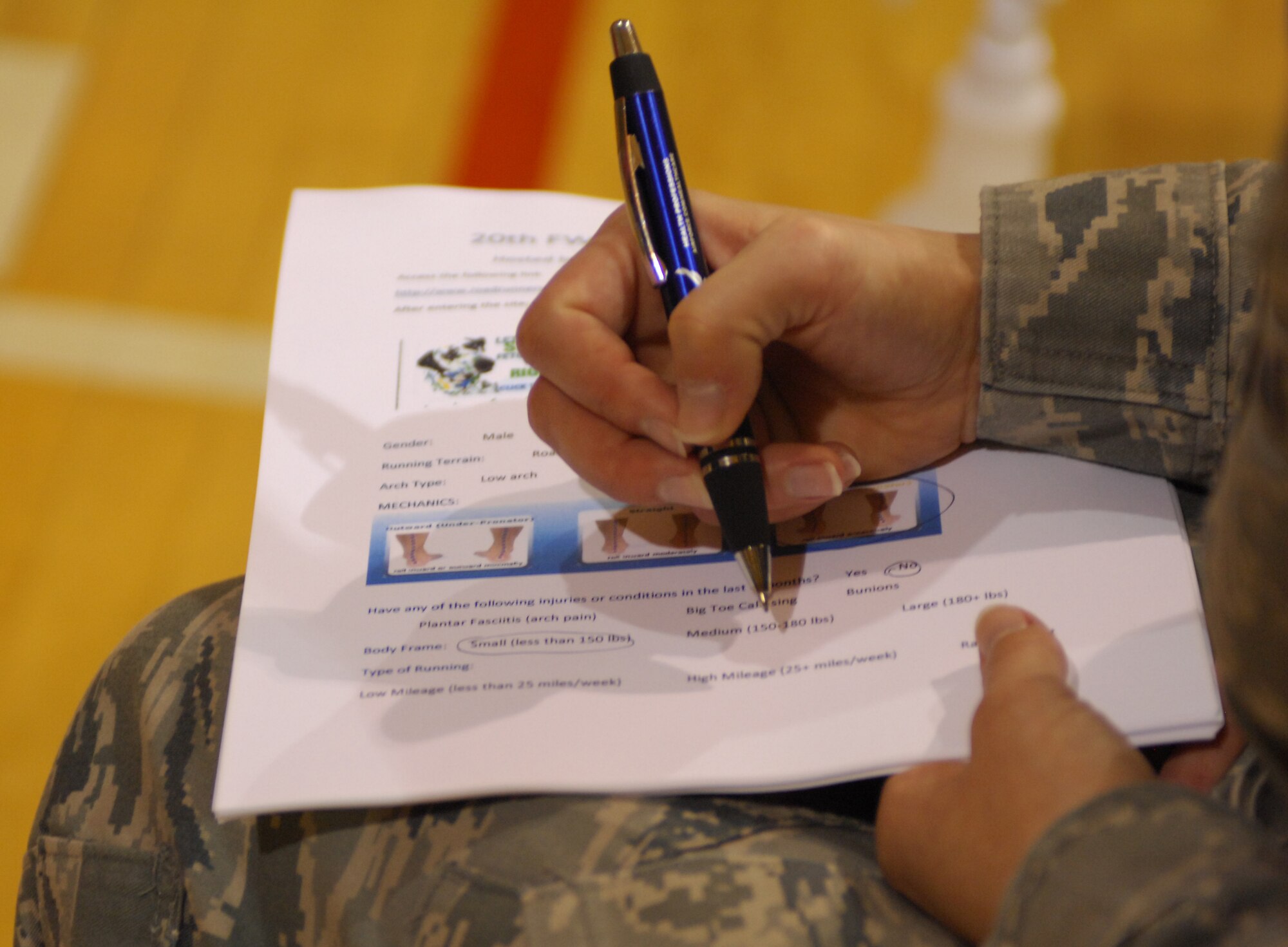 Staff Sgt. Sharon Munster, 20th Medical Group physical therapy flight non-commissioned officer in charge, fills out paperwork during the running shoe clinic at the Shaw fitness center April 13, 2011. The Health and Wellness Center sponsored the running shoe clinic to provide advice and assistance on Team Shaw members' selection of shoes.  (U.S. Air Force photo by Senior Airman Alexandria Mosness)