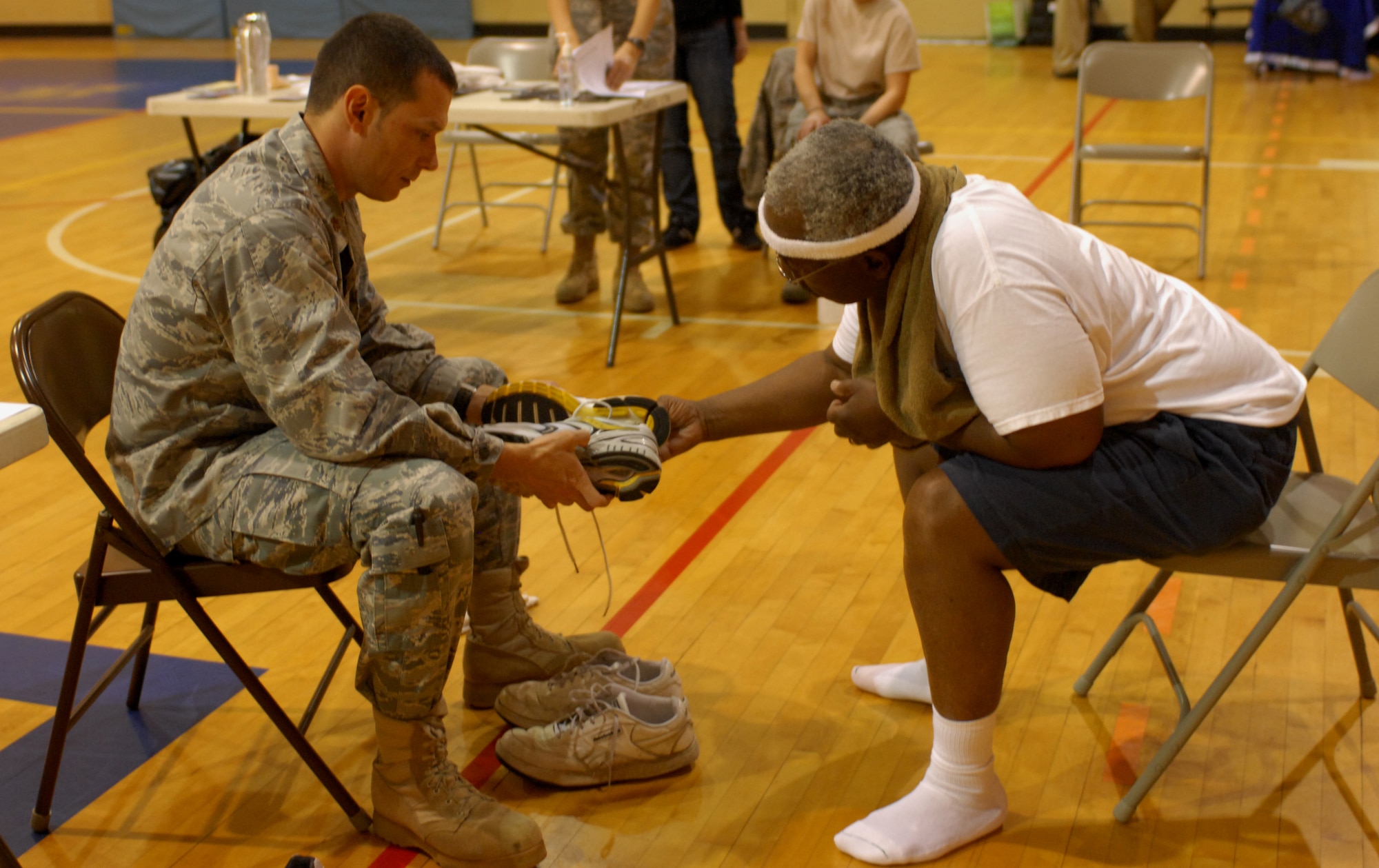 Maj. Justin Martin, 20th Medical Group physical therapy flight commander, gives advice on Chief Master Sgt. (ret.) Sam Belin's shoe choice during the running shoe clinic at the Shaw Fitness Center April 13, 2011. The Health and Wellness Center sponsored the running shoe clinic to provide advice and assistance on Team Shaw members' selection of shoes.  (U.S. Air Force photo by Senior Airman Alexandria Mosness)