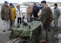 MINOT AIR FORCE BASE, N.D. – A group of Canadian visitors receive a brief showcasing weapons and equipment used by members of the 91st Security Forces Group during a base tour here April 16. The tour was part of the festivities surrounding the 23rd annual International Military Ball, held at the Minot Holiday Inn.  The Chair of the Minot Area Chamber of Commerce, and the commanders of the 5th Bomb Wing and 91st Missile Wing, sponsored the ball, which featured the Heartland of America Band, Night Wing, and dignitaries from both the United States and Canada. (U.S. Air Force photo/Tech. Sgt. Thomas Dow)