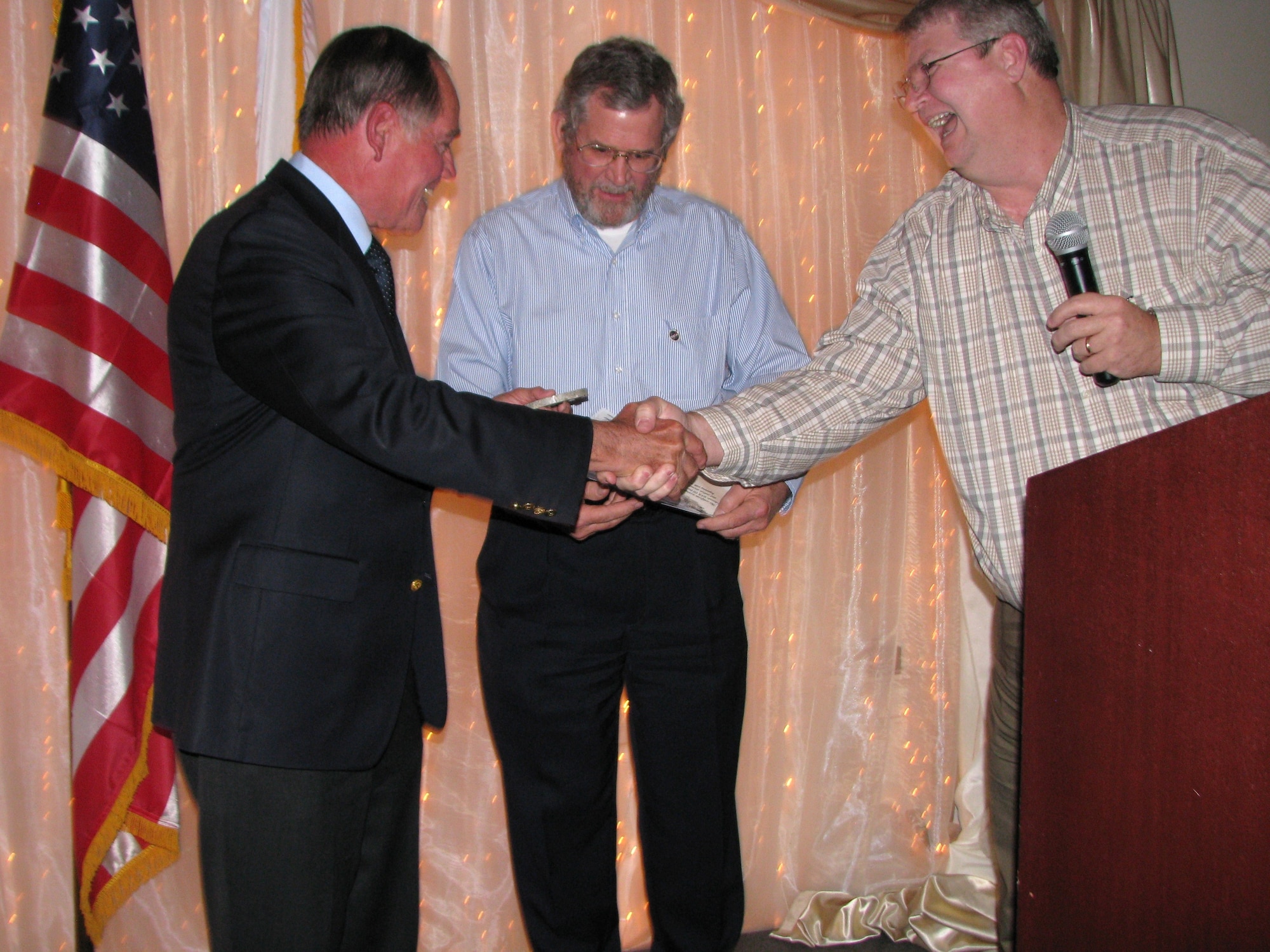 Ken Crawford, 95th Air Base Wing Runway project manager for Edwards Air Force Base (center) and George Grimshaw, Director of Shuttle Operations for NASA Dryden (right) present retired Capt. Robert Crippen with a piece of Runway 22 at a dinner at Antelope Valley University April 15. Captain Crippen was the pilot for STS-1, the first space shuttle flight, which occurred 30 years ago. (Air Force photo by Diane Betzler)