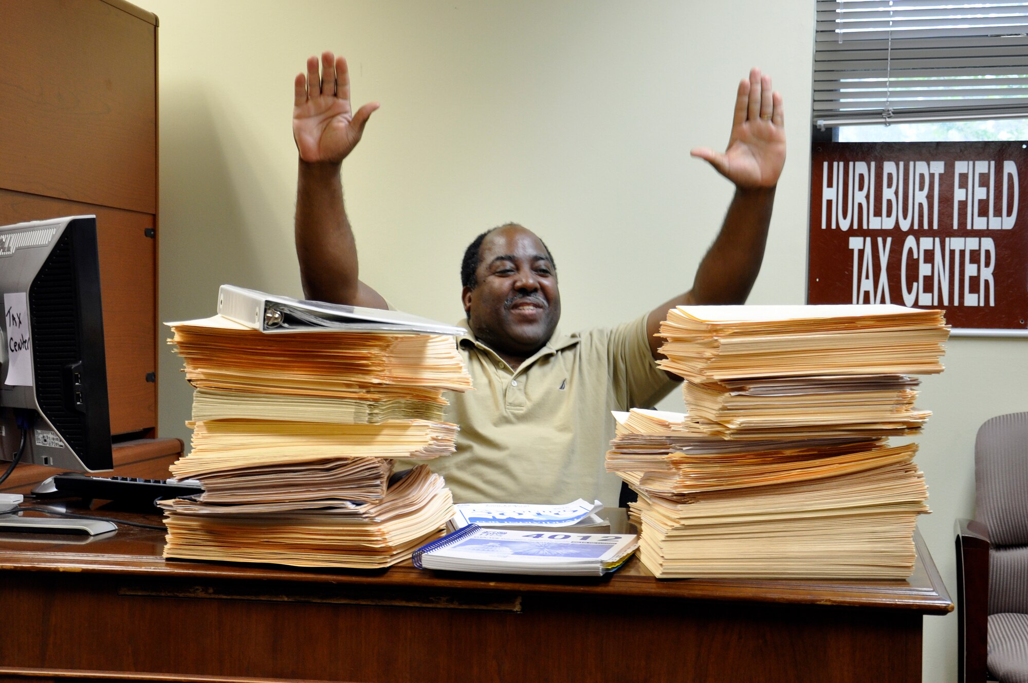 Wayne Smith, Hurlburt Tax Center manager, throws his arms up in the classic “I’m done!” move, celebrating the end of the 2010 tax season – right before he starts working on the stacks of returns from last-minute filers still needing review. These stacks only account for about one-fourth of the more than 3,000 returns done by the Tax Center in 13 weeks.  Volunteers handled both federal and state income taxes for active-duty military members, civilians, retirees and dependents. (U.S. Air Force photo/Master Sgt. Scott MacKay)