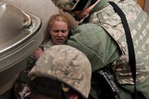 MINOT AIR FORCE BASE N.D. -- Staff Sgt. Daniel Rumfelt, 5th Security Forces Squadron security forces member, assists Capt. Michelle Olinger, 91st Missile Wing chief of inspection, during an active shooter exercise here April 19. This exercise scenario is designed to evaluate the base's implementation of force protection condition response measures as well as test the readiness and effectiveness of emergency response units. (U.S. Air Force photo/ Airman 1st Class Aaron-Forrest Wainwright)