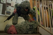 MINOT AIR FORCE BASE N.D. -- Airman 1st Class Andrew Sertich, 5th Security Forces Squadron security forces member, detains Tech. Sgt. Donovan Womack, 91st Operation Support Squadron NCO in charge of training, as a possible gunman during an active shooter exercise here April 19. This exercise scenario is designed to evaluate the base's implementation of force protection condition response measures as well as test the readiness and effectiveness of emergency response units. (U.S. Air Force photo/ Airman 1st Class Aaron-Forrest Wainwright)