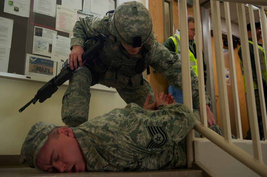 MINOT AIR FORCE BASE N.D. -- Airman 1st Class Andrew Sertich, 5th Security Forces Squadron security forces member, detains Tech. Sgt. Donovan Womack, 91st Operation Support Squadron NCO in charge of training, as a possible gunman during an active shooter exercise here April 19. This exercise scenario is designed to evaluate the base's implementation of force protection condition response measures as well as test the readiness and effectiveness of emergency response units. (U.S. Air Force photo/ Airman 1st Class Aaron-Forrest Wainwright)