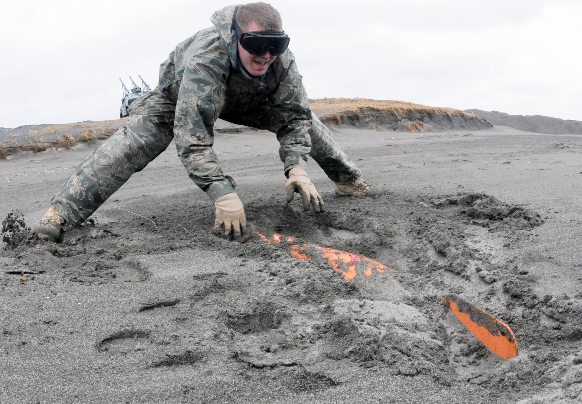 U.S. Air Force Staff Sgt. Ryan Johnson, an Explosive Ordnance Disposal Technician with the 35th Civil Engineer Squadron from Misawa AB, and a Shoemakersville, Pa.-native, uncovers a Bomb Dummy Unit – 50 practice munition at Draughon Bombing Range April 8 after the tsunami swept through the area wiping out the targets and spreading munitions across the beach.  Explosive Ordnance Disposal teams uncover the munitions and blow them up with C-4 explosives to prepare for clean up crew to come through and remove the remaining fragments.  This is part of the Misawa AB recovery effort in support of Operation Tomodachi.