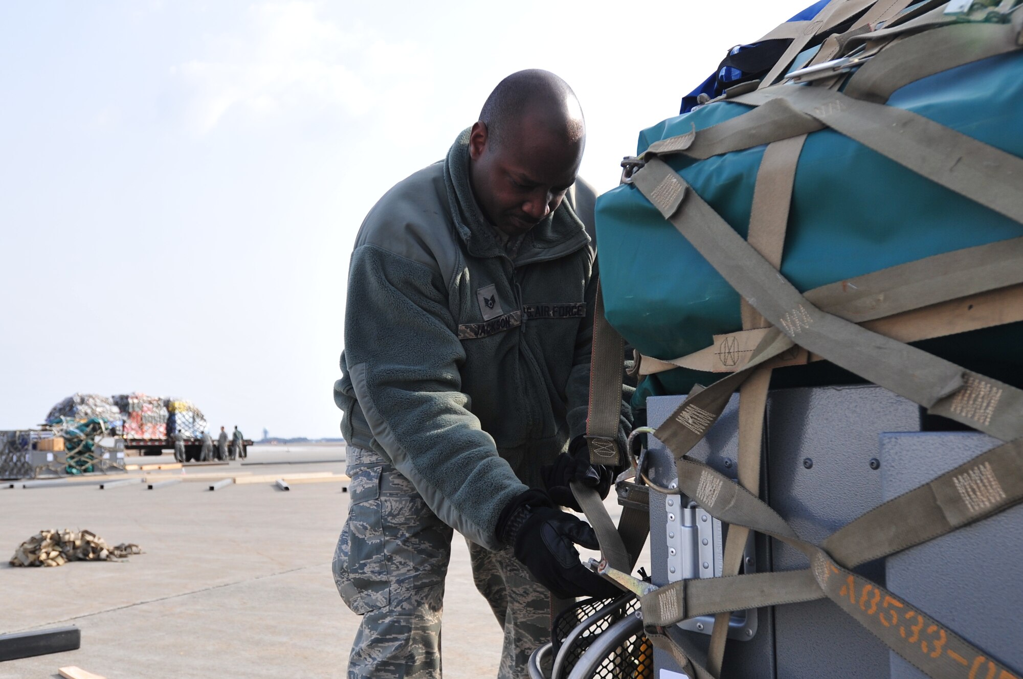 U.S. Air Force Staff Sgt. Greg Jackson, a Non-commissioned Officer in Charge of Inbound and outbound shipments with the 35th Logistics Readiness Squadron from Misawa AB, and a West Monroe, La.-native, secures the cargo straps from one of the 30 pallets of equipment and supplies transported to Sendai, Japan as part of the U.S. and U.K. Search and Rescue Teams brought in to provide Disaster Relief in support of Operation Tomodachi on April 4, 2011.