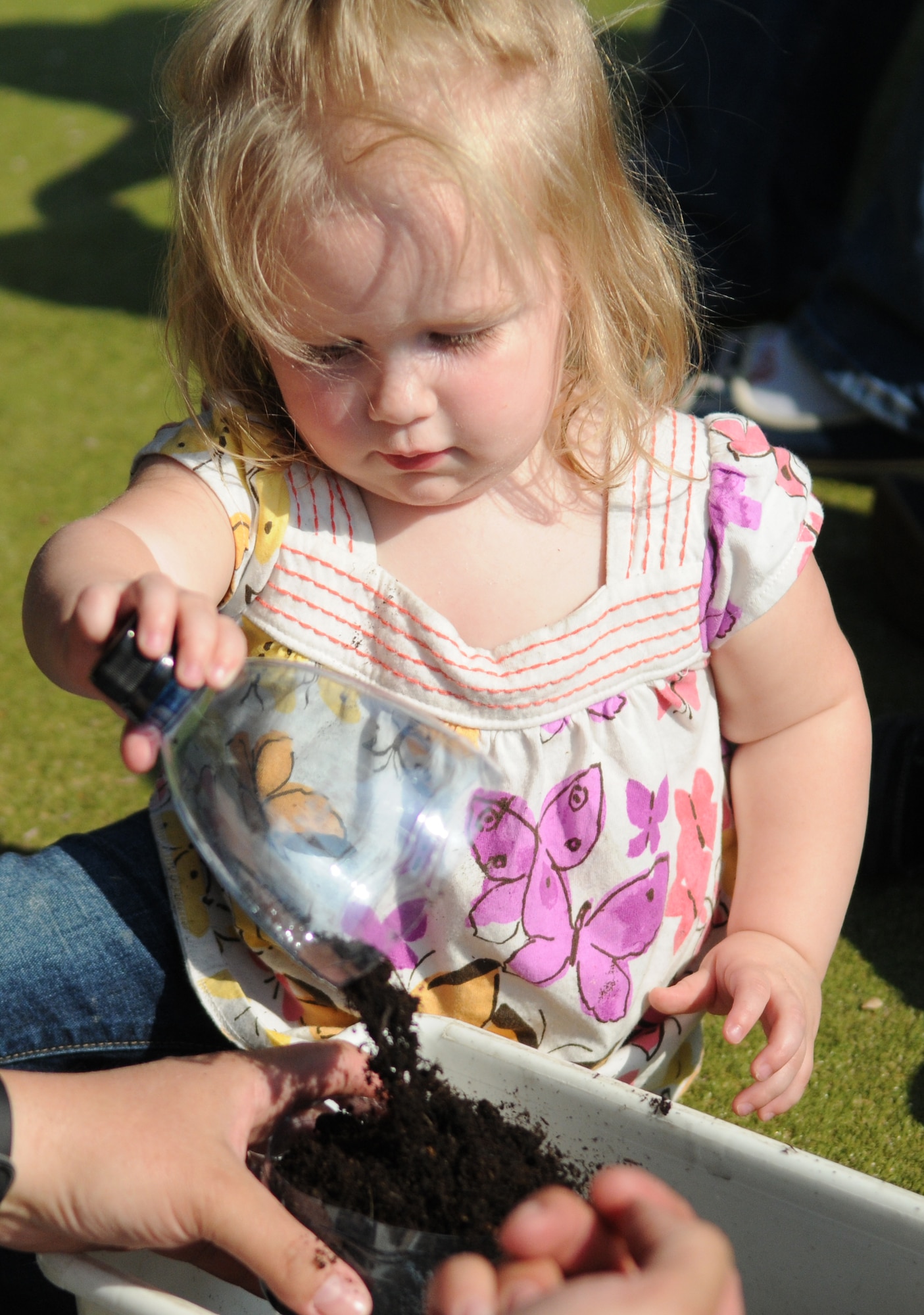 RAF MILDENHALL, England -- Cameryn, daughter of Tech. Sgt. Frank Castonguay, 100th Maintenance Squadron, pours dirt into a container while planting a plant during an Earth Week event at the RAF Mildenhall Child Development Center April 19, 2011. Along with planting plants, children from the CDC also made t-shirts in honor of Earth Week. Earth Week is a week-long celebration of Earth Day between RAFs Mildenhall and Lakenheath. (U.S. Air Force photo/Airman 1st Class Rachel Waller)