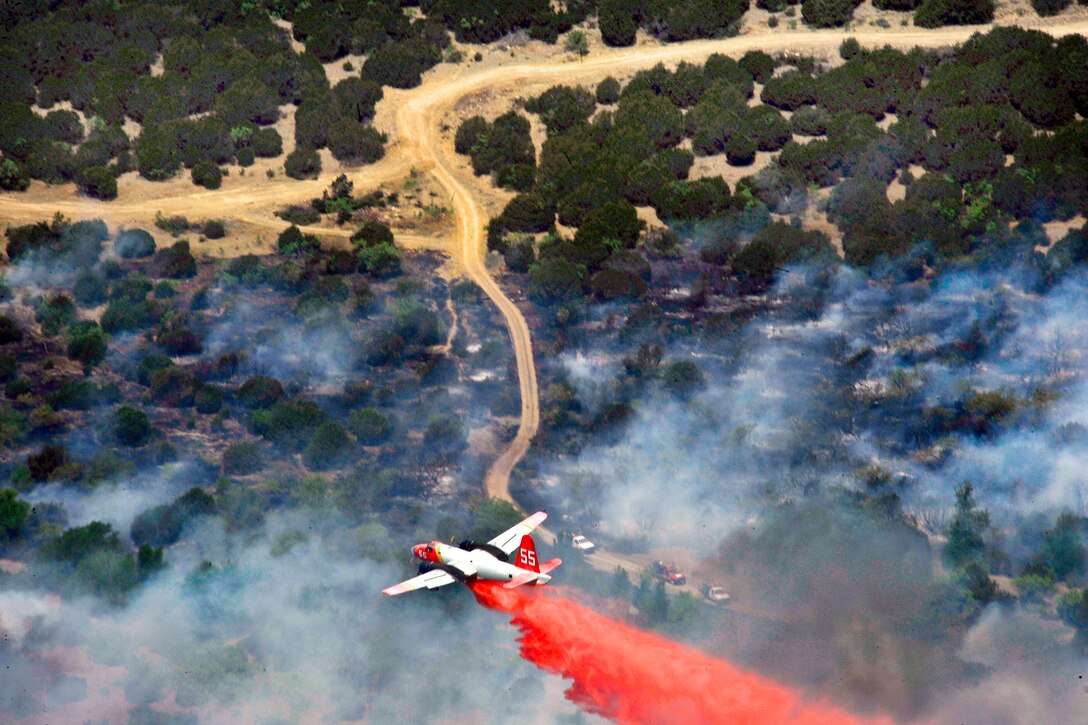A Minden Air Lockheed SP-2H Neptune tanker drops flame retardant on wildfires burning across Texas, April 19, 2011. The U.S. Air Force and Air National Guard have helped the U.S. Forest Service and other agencies contain the fires, which burned more than 1,000 square miles of land.