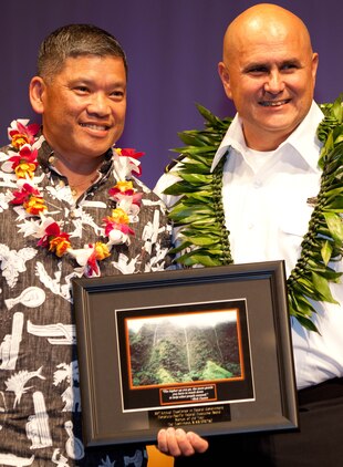 Ted Hashimoto (left), the All-Hazards Branch head for U.S. Marine Corps Forces, Pacific’s Current Operations and Plans section, accepts the Mentor of the Year Award from Army Maj. Gen. Joseph Chaves, deputy commanding general for the Army National Guard, U.S. Army, Pacific, for his contributions to training and mentoring the most junior to the most senior service members in his section during the 55th Annual Excellence in Federal Government Awards Luncheon and Expo April 21 at the Sheraton Waikiki Hotel, here. The event was held to recognize federal employees for their contributions and excellence within their agency.