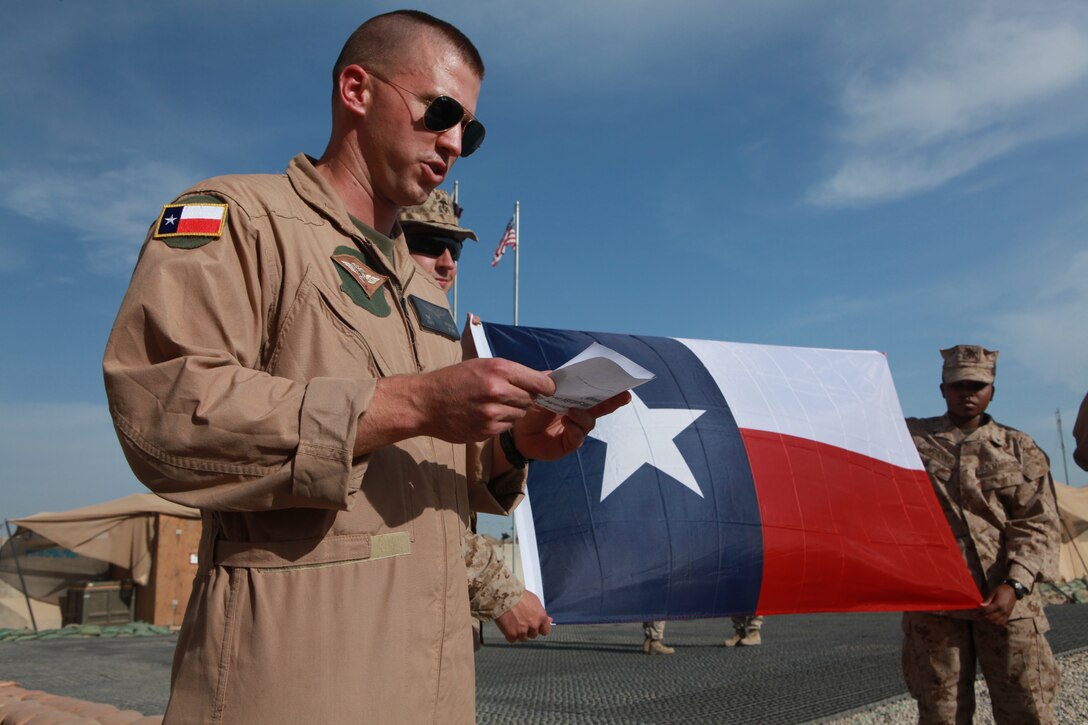 Capt. Wesley R. Ogden, a fixed wing planner with 2nd Marine Aircraft Wing (Forward), reads a speech he prepared for a remembrance ceremony on San Jacinto Day at the 2nd MAW (Fwd.) headquarters compound on Camp Leatherneck, Afghanistan, April 21. San Jacinto Day commemorates a battle between the Texas Army and Mexican forces and is considered the turning point for Texas' independence from Mexico, April 21, 1836. “I decided to offer an opportunity for us to gather in remembrance, here, for motivation and morale,” said Ogden, a native of Houston. “It's beneficial to honor the traditions, values, and customs of the state and country that we joined to defend.  It reminds us why we're Marines.”