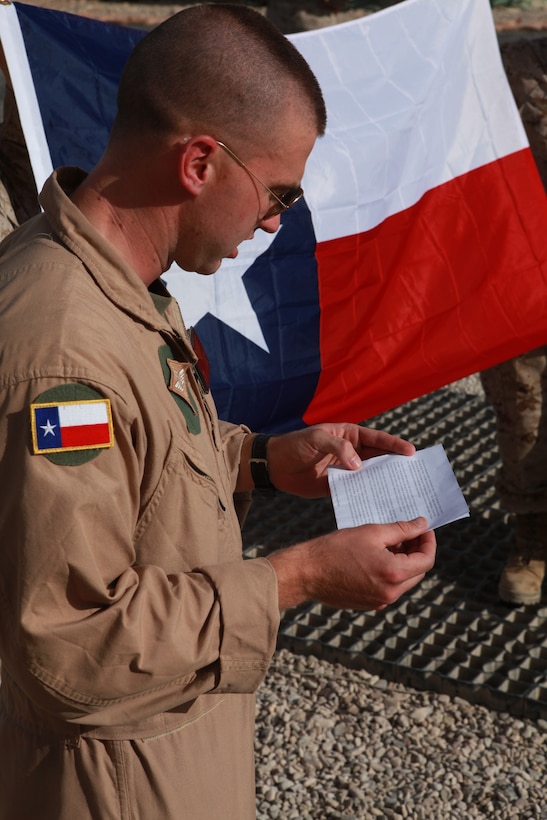 Capt. Wesley R. Ogden, a fixed wing planner with 2nd Marine Aircraft Wing (Forward), reads a speech he prepared for a remembrance ceremony on San Jacinto Day at the 2nd MAW (Fwd.) headquarters compound on Camp Leatherneck, Afghanistan, April 21. San Jacinto Day commemorates a battle between the Texas Army and Mexican forces and is considered the turning point for Texas' independence from Mexico, April 21, 1836. “I decided to offer an opportunity for us to gather in remembrance, here, for motivation and morale,” said Ogden, a native of Houston. “It's beneficial to honor the traditions, values, and customs of the state and country that we joined to defend.  It reminds us why we're Marines.”
