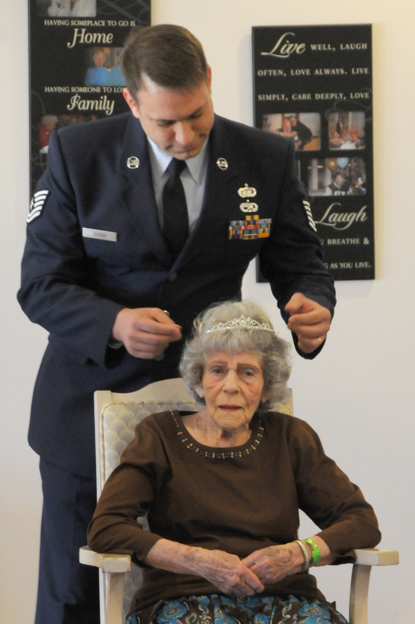 Tech. Sgt. Michael Shirar, 173rd Fighter Wing Maintenace Training Manager, places a tiara onMrs. Irene Dalton, the 2011 Rose Queen Princess, head during the ceremony.  Members of the Oregon Air National Guard volunteered to help with the 2011 Rose Queen Corenation ceremony at Plum Ridge Marquis Care in Klamath Falls, Ore. April 8, 2011. (U.S. Air Force Photo by Tech.Sgt. Jennifer Shirar, RELEASED)