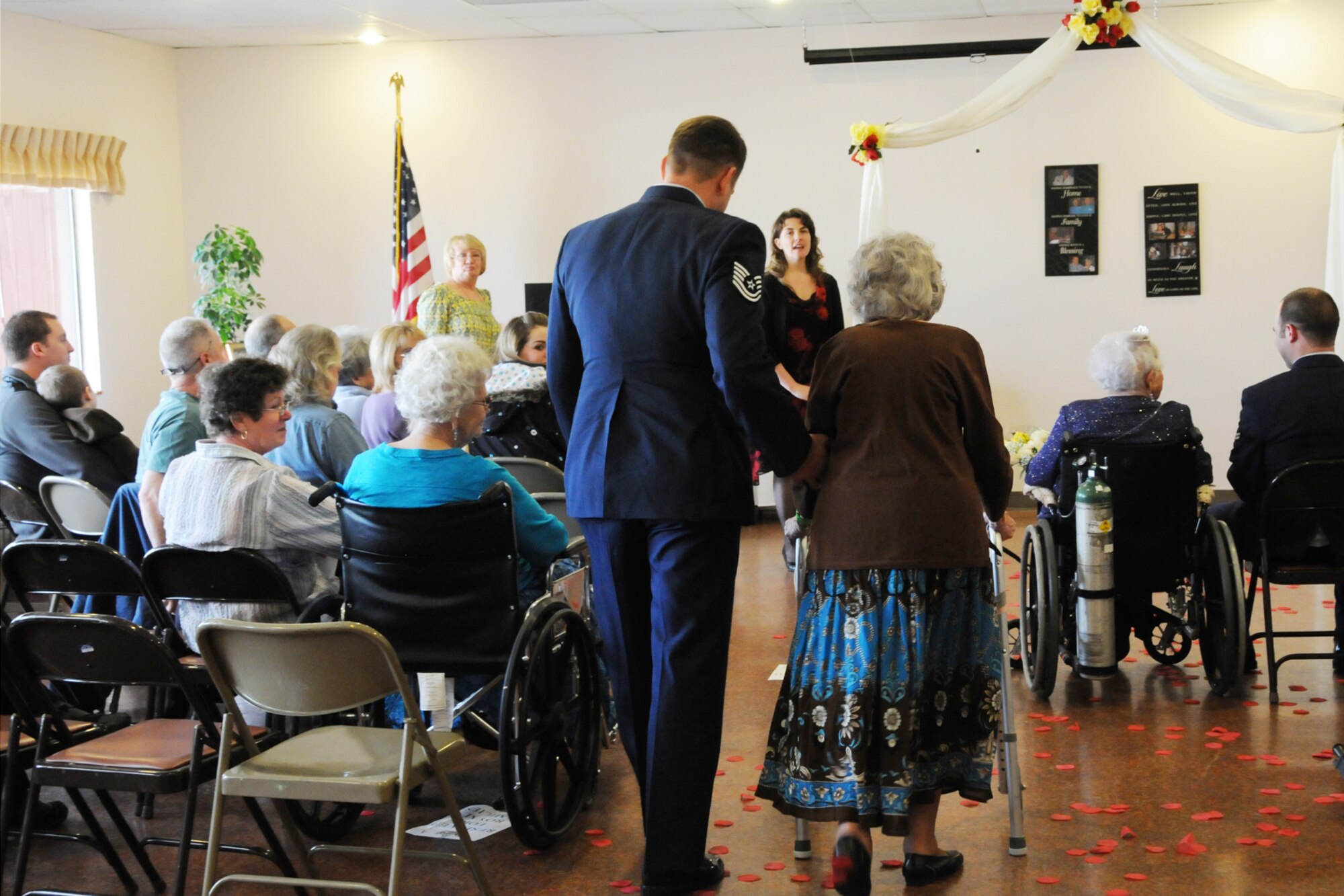 Tech. Sgt. Michael Shirar, 173rd Fighter Wing Maintenace Training Manager, escorts  Mrs. Irene Dalton, the 2011 Rose Queen Princess,to the stage during the ceremony.  Members of the Oregon Air National Guard volunteered to help with the 2011 Rose Queen Corenation ceremony at Plum Ridge Marquis Care in Klamath Falls, Ore. April 8, 2011. (U.S. Air Force Photo by Tech.Sgt. Jennifer Shirar, RELEASED)