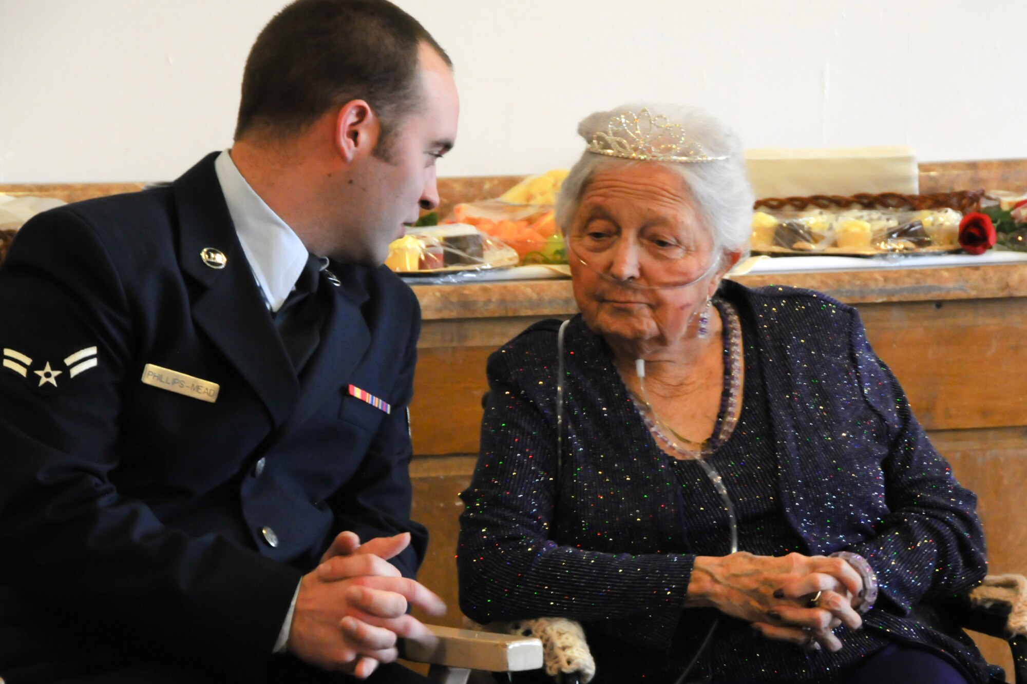 Airman First Class Jesse Phillips-Meade, 270th Air Traffic Control Squadron, talks with Mrs. Jessie Spillane,the 2010 reigning Rose Queen, before the ceremony.  Members of the Oregon Air National Guard volunteered to help with the 2011 Rose Queen Corenation ceremony at Plum Ridge Marquis Care in Klamath Falls, Ore. April 8, 2011. (U.S. Air Force Photo by Tech.Sgt. Jennifer Shirar, RELEASED)