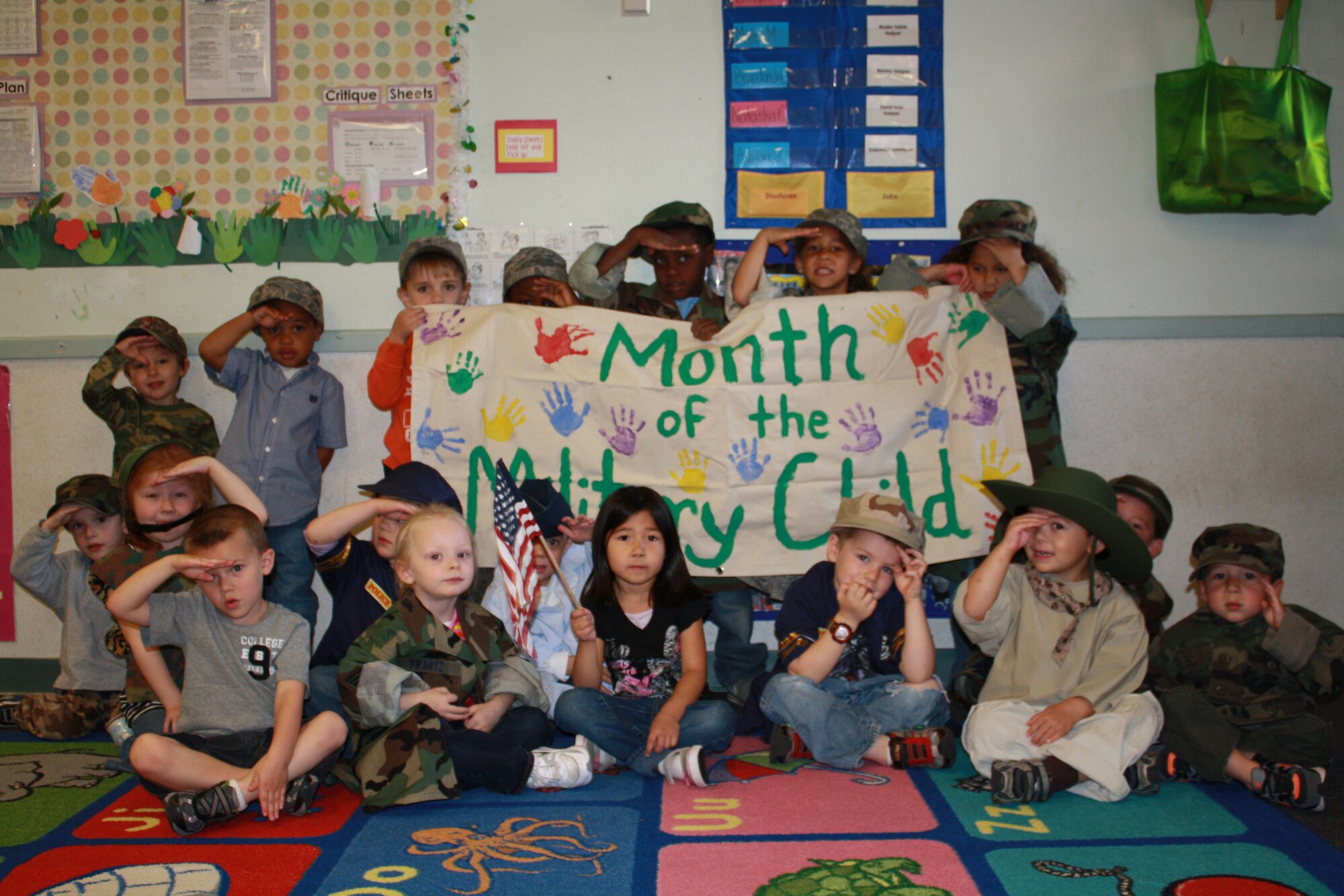 Children at the Cannon Air Force Base, N.M., Child Development Center dressed in their parents' uniforms to observe Month of the Military Child salute for a photo April 8, 2011.  The kids drew pictures expressing what it means to be a military child, read books, sang songs, and participated in other activities to celebrate being military children.  (photo by Alma Castaneda)(RELEASED)