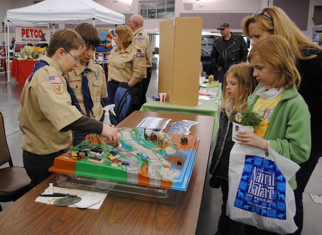 Duncan, 10, (left) and Thomas, 11, Clarke, both members of the Boy Scouts Troop 43 from Malmstrom, perform a stormwater pollution demonstration to Lindy Garner and her daughters Callan, 10, and Jadan, 6.  The Scouts used cocoa and Kool-aid to represent pollutants that enter the Missouri River when it rains.  (U.S. Air Force photo/Airman Cortney Hansen)